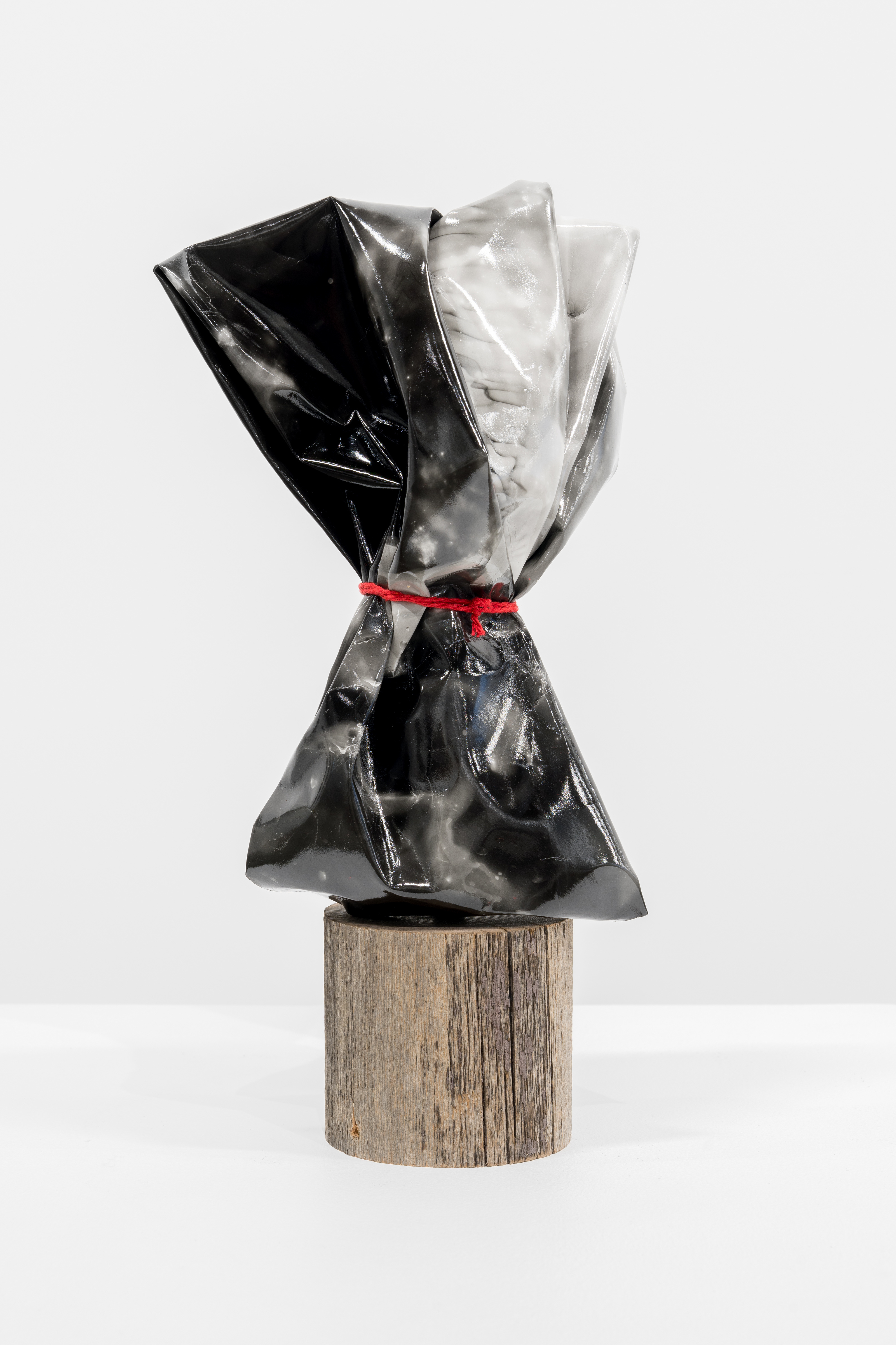 A black and white sculpture on a wooden stand.