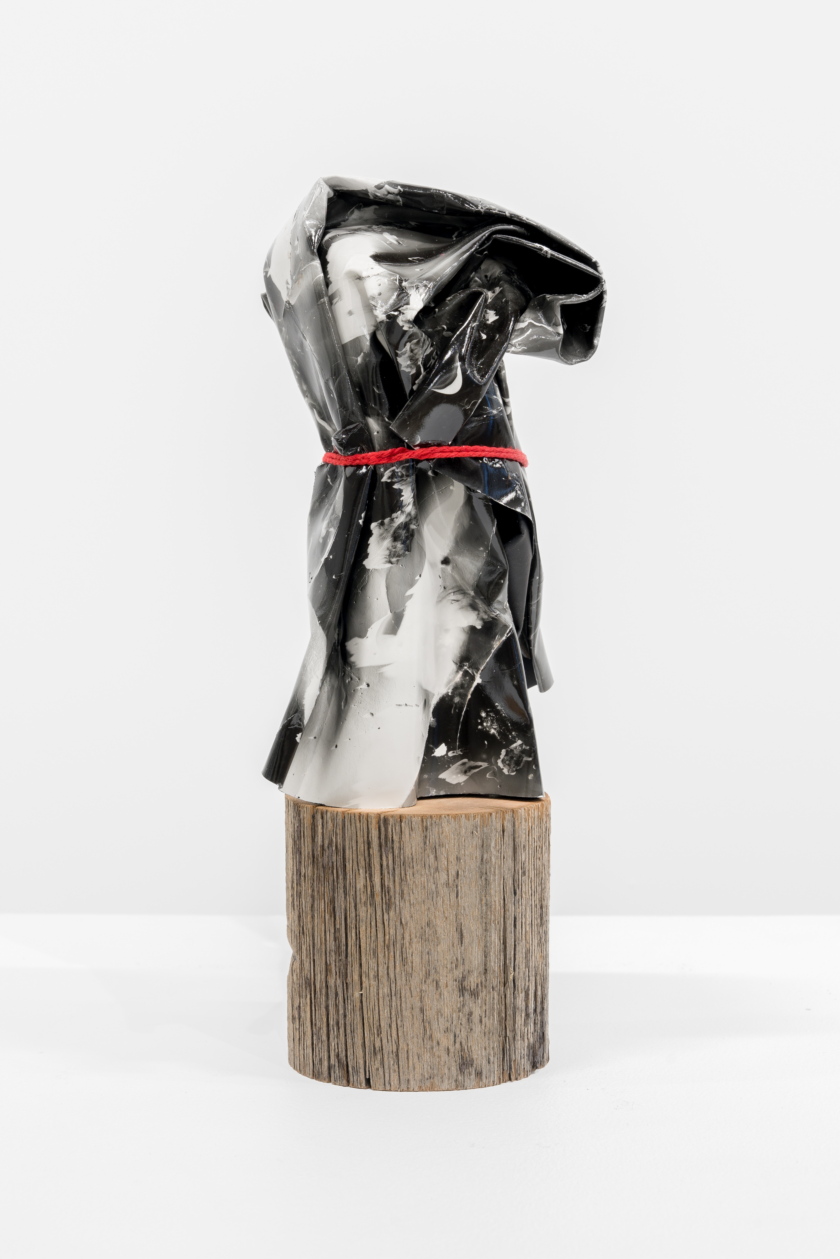 A black and white sculpture on a wooden block.