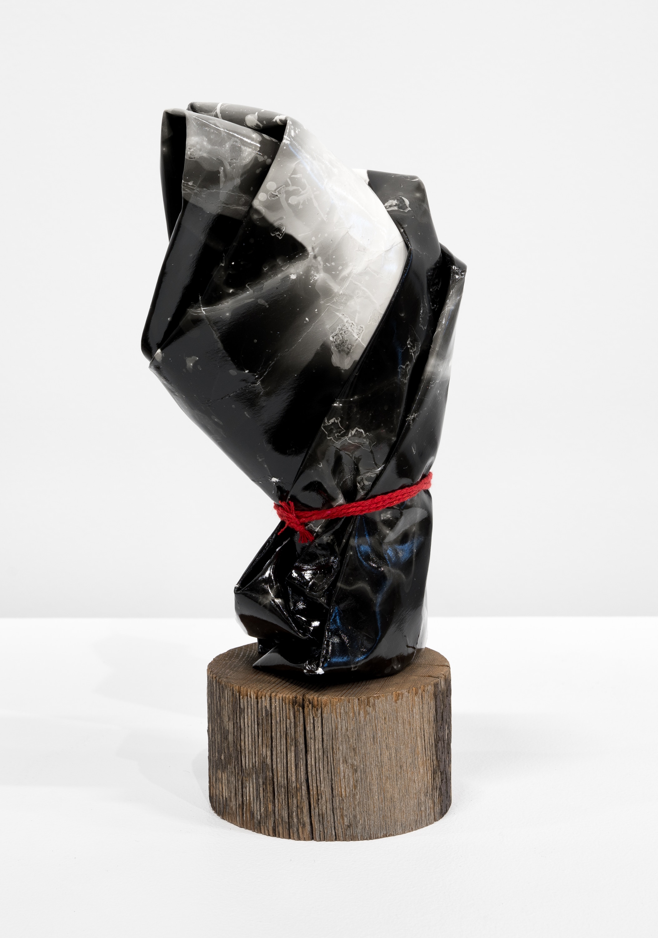 A black and white sculpture on a wooden base.