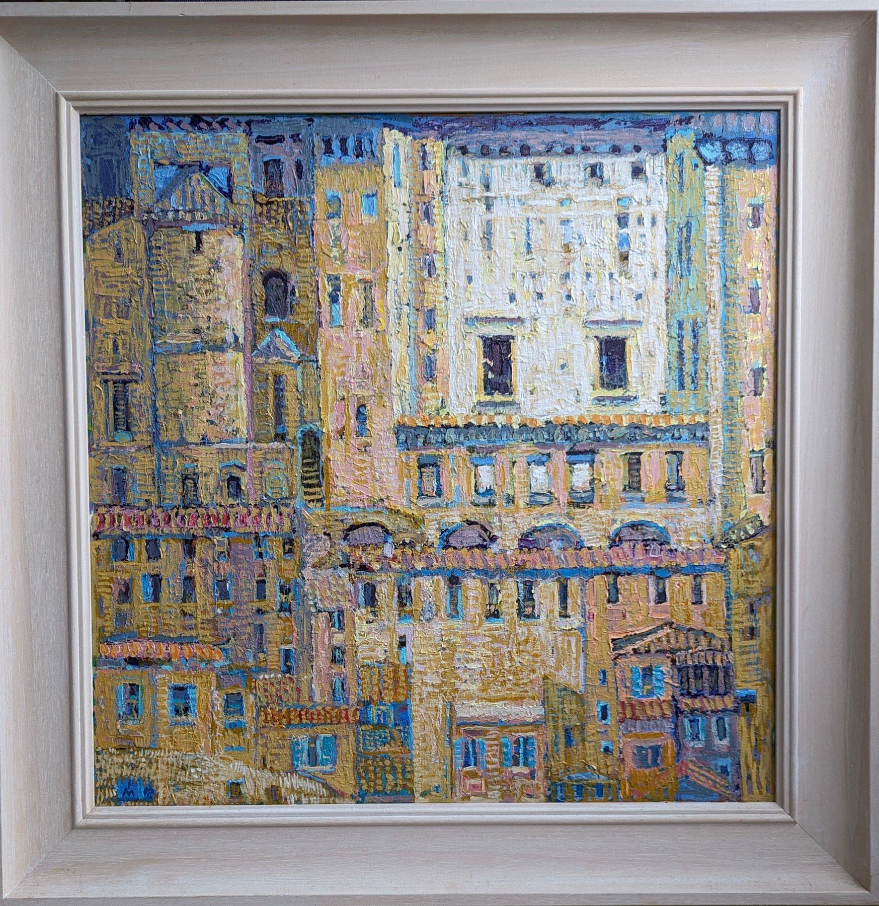 A painting of a cityscape in a white frame.