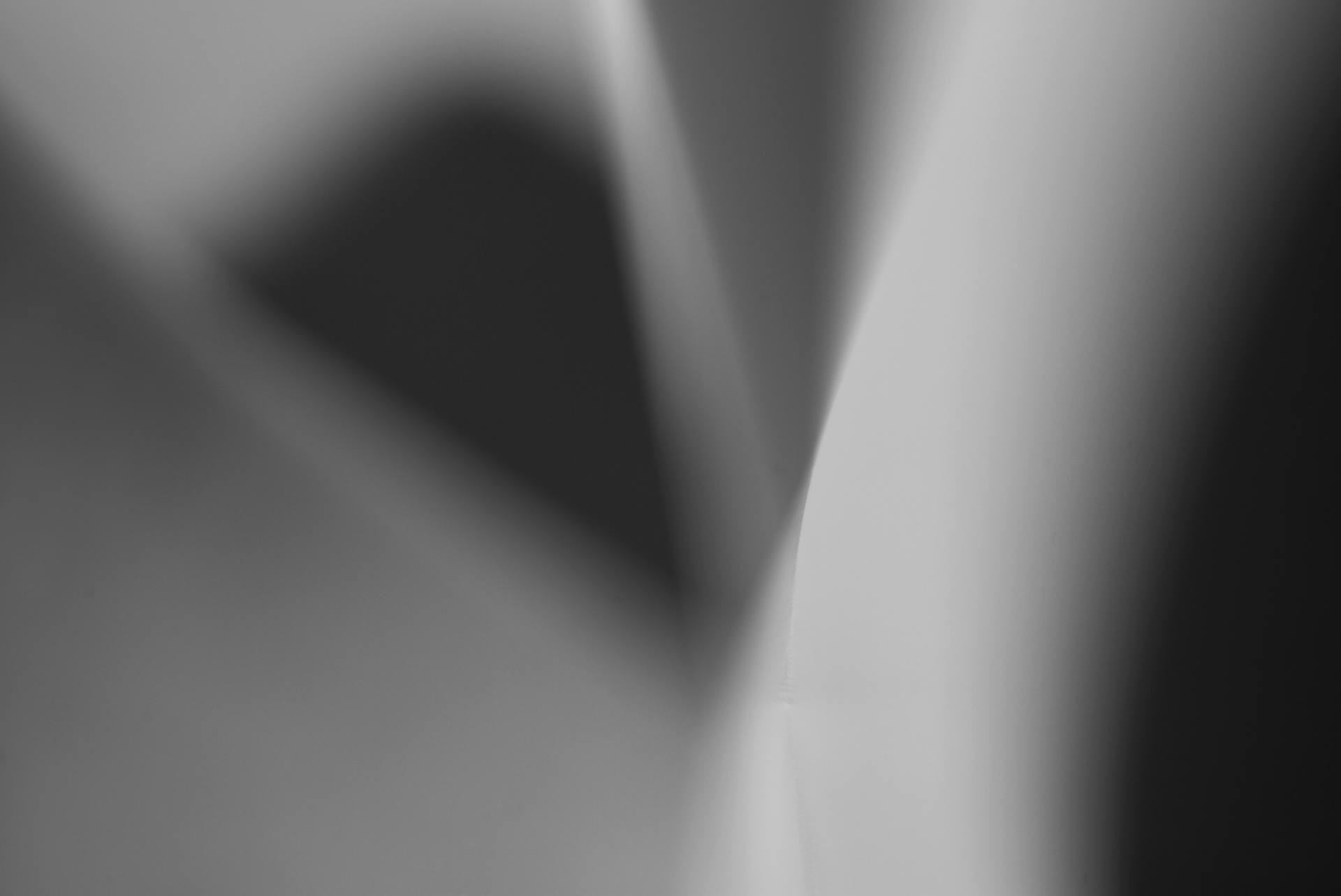 A black and white photo of a light shining through a window.