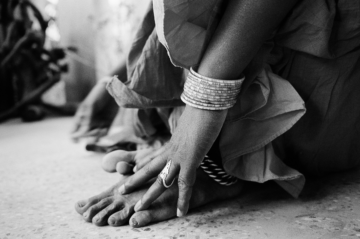A black and white photo of a woman's feet with bracelets on them.