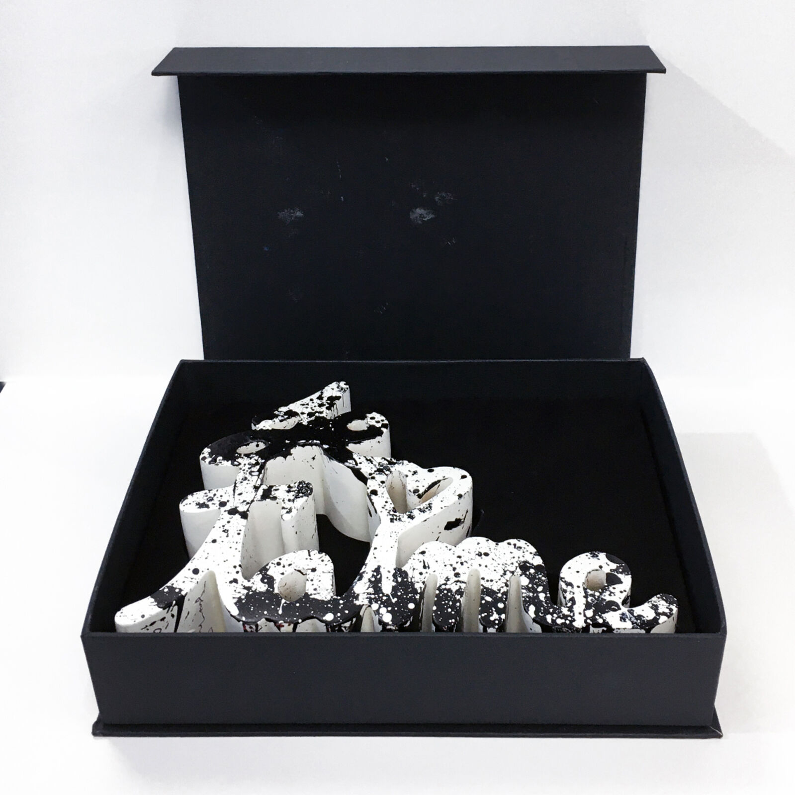 A black and white sculpture of the word love on a white background.