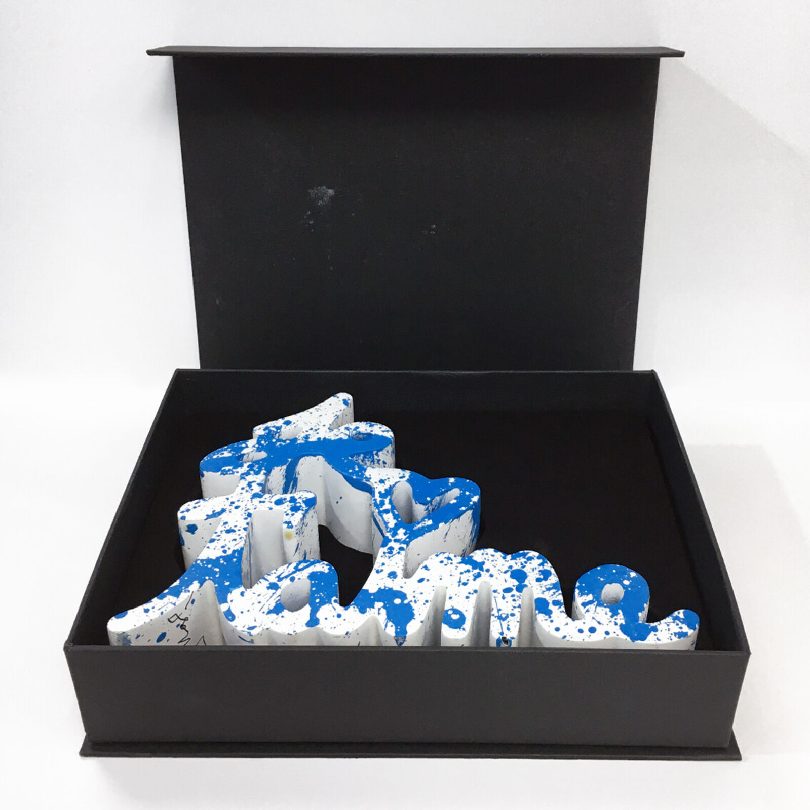 A blue and white sign that says "love" on a white background.