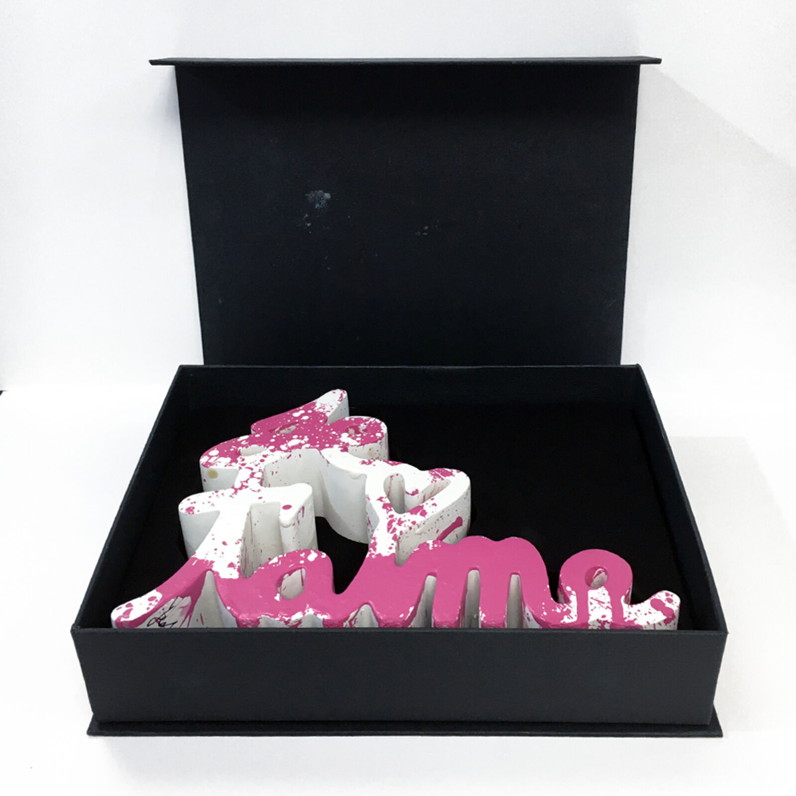 A pink and white wooden sign that says "love" on a white background.