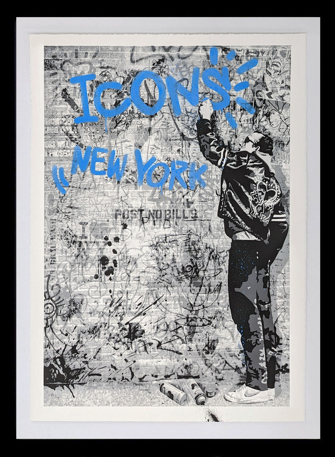 A black and white photo of a man standing in front of a wall with graffiti.