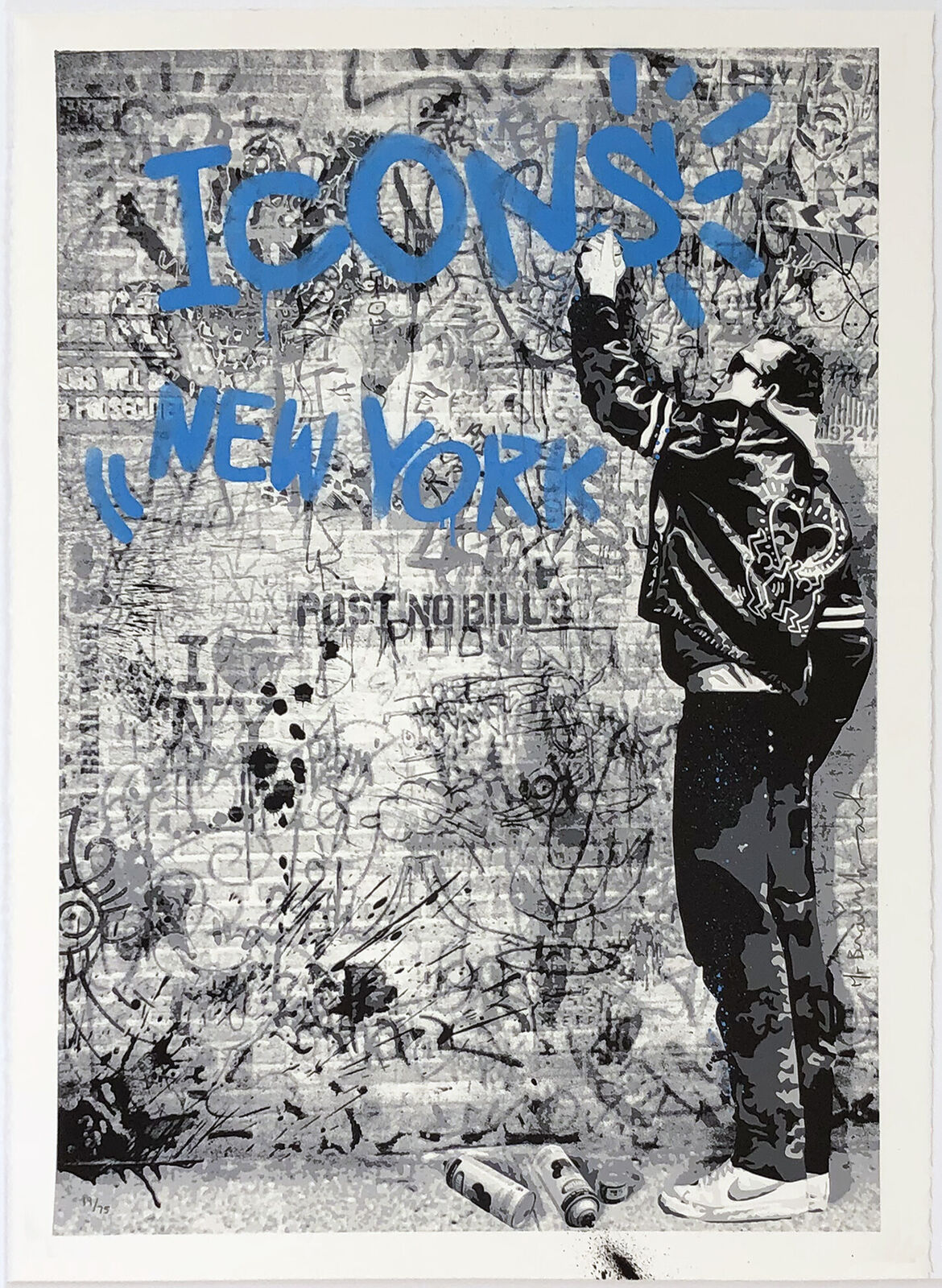 A black and white photo of a man standing in front of a wall with graffiti.