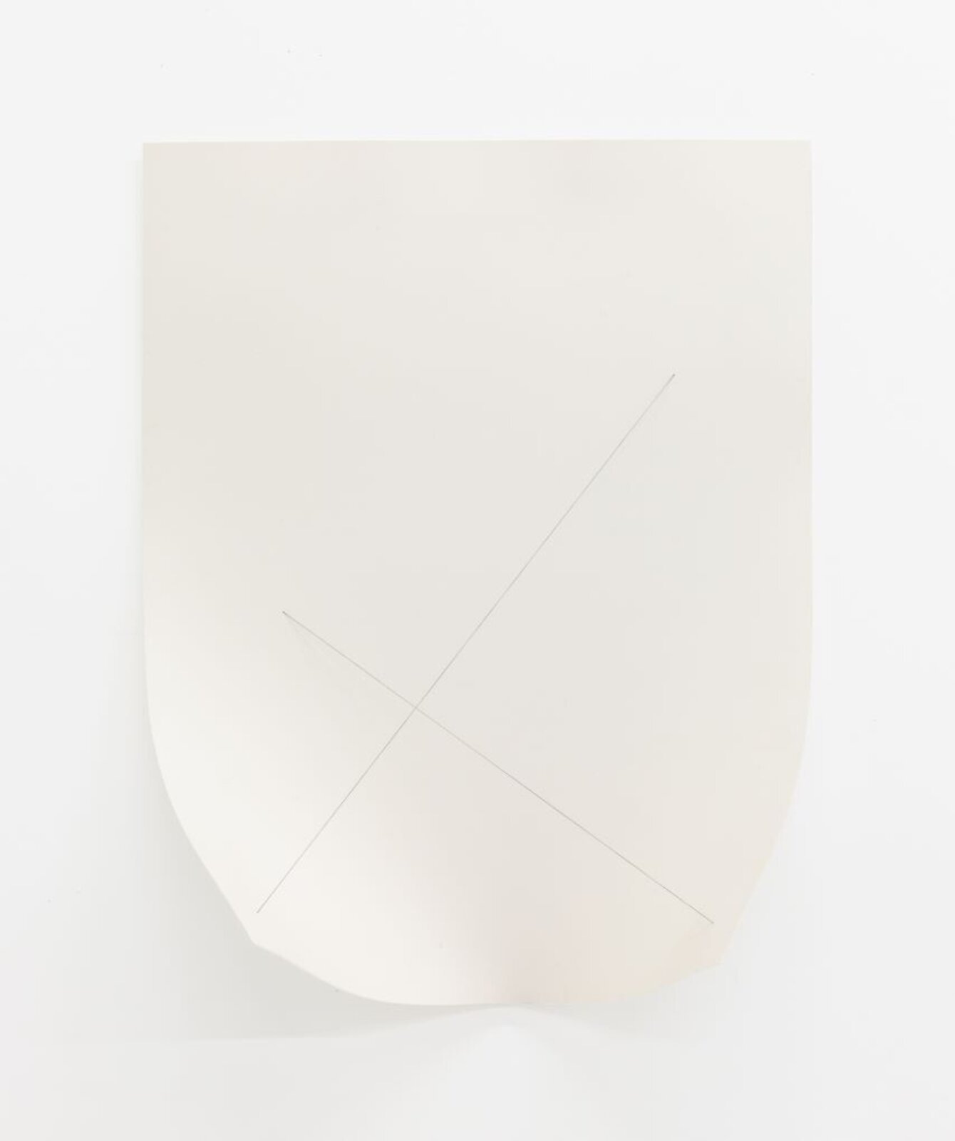 A minimalist composition featuring a folded sheet of paper with a subtle cross mark.
