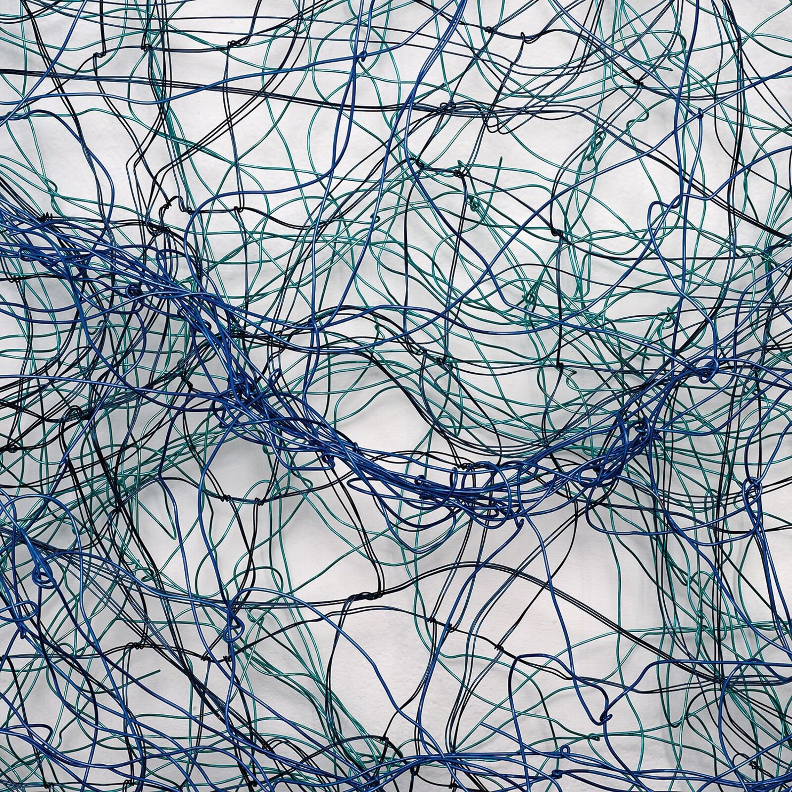 A square wire sculpture with a tangled, organic pattern in shades of blue and black against a white background.