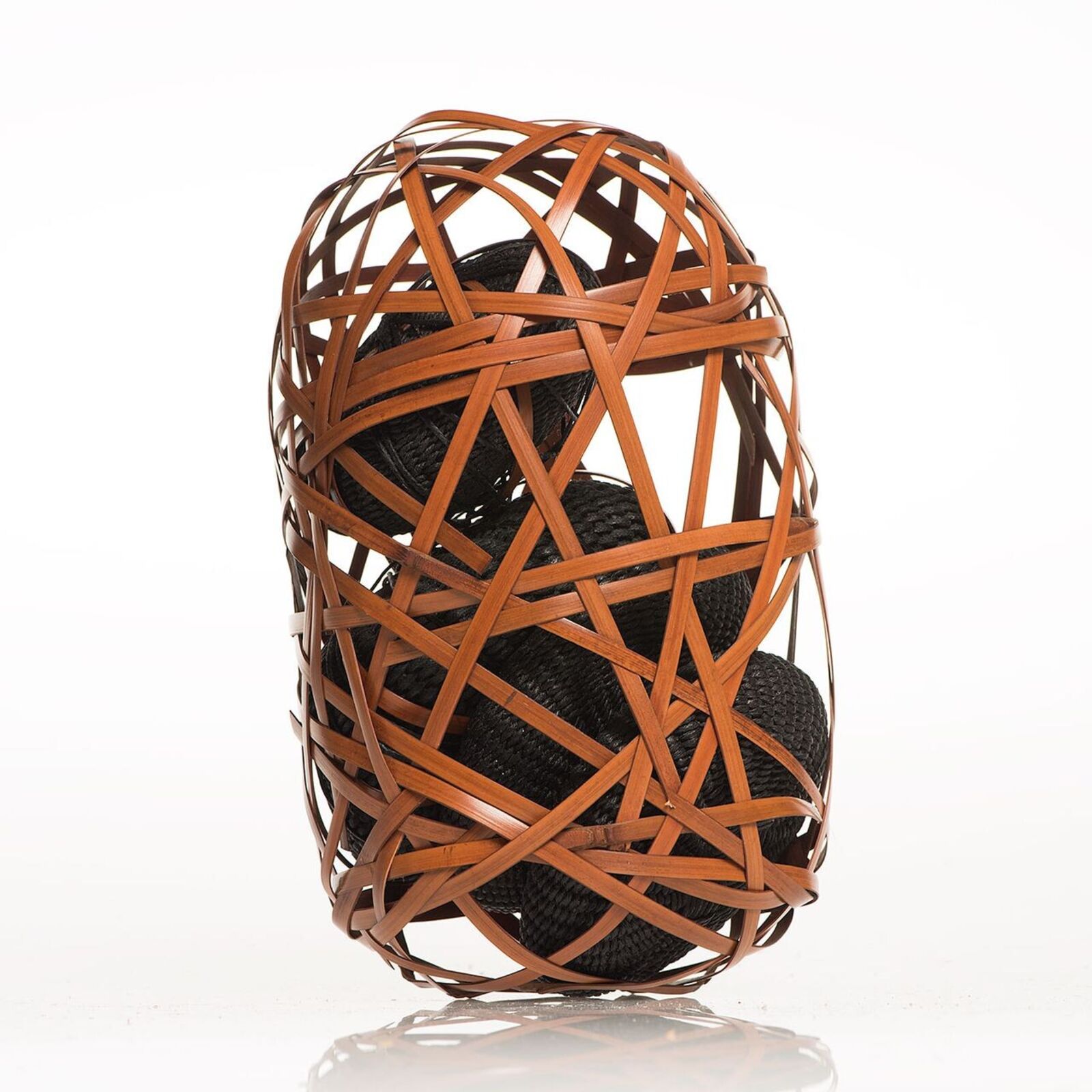 A woven basket containing dark, textured spheres against a stark white background.
