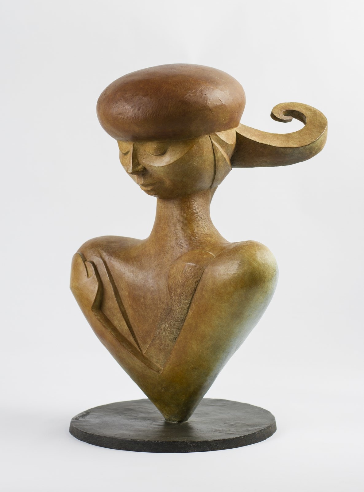 A wooden sculpture of a woman with a hat on her head.