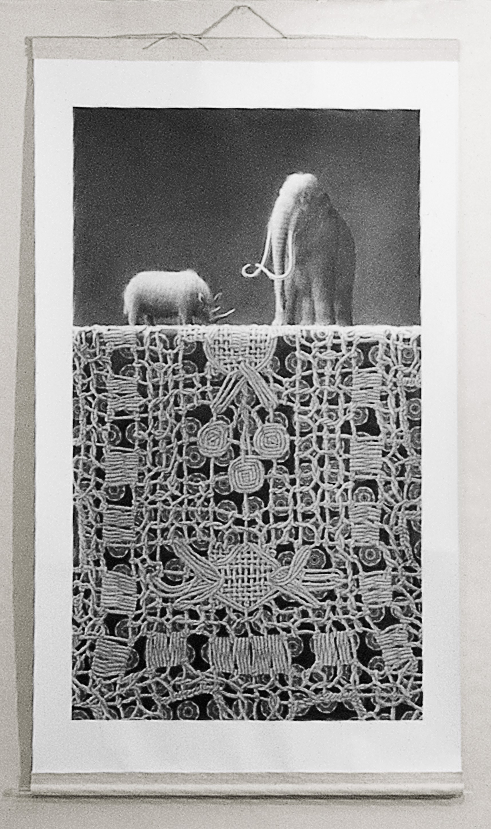 A black and white photo of two elephants on a wall.