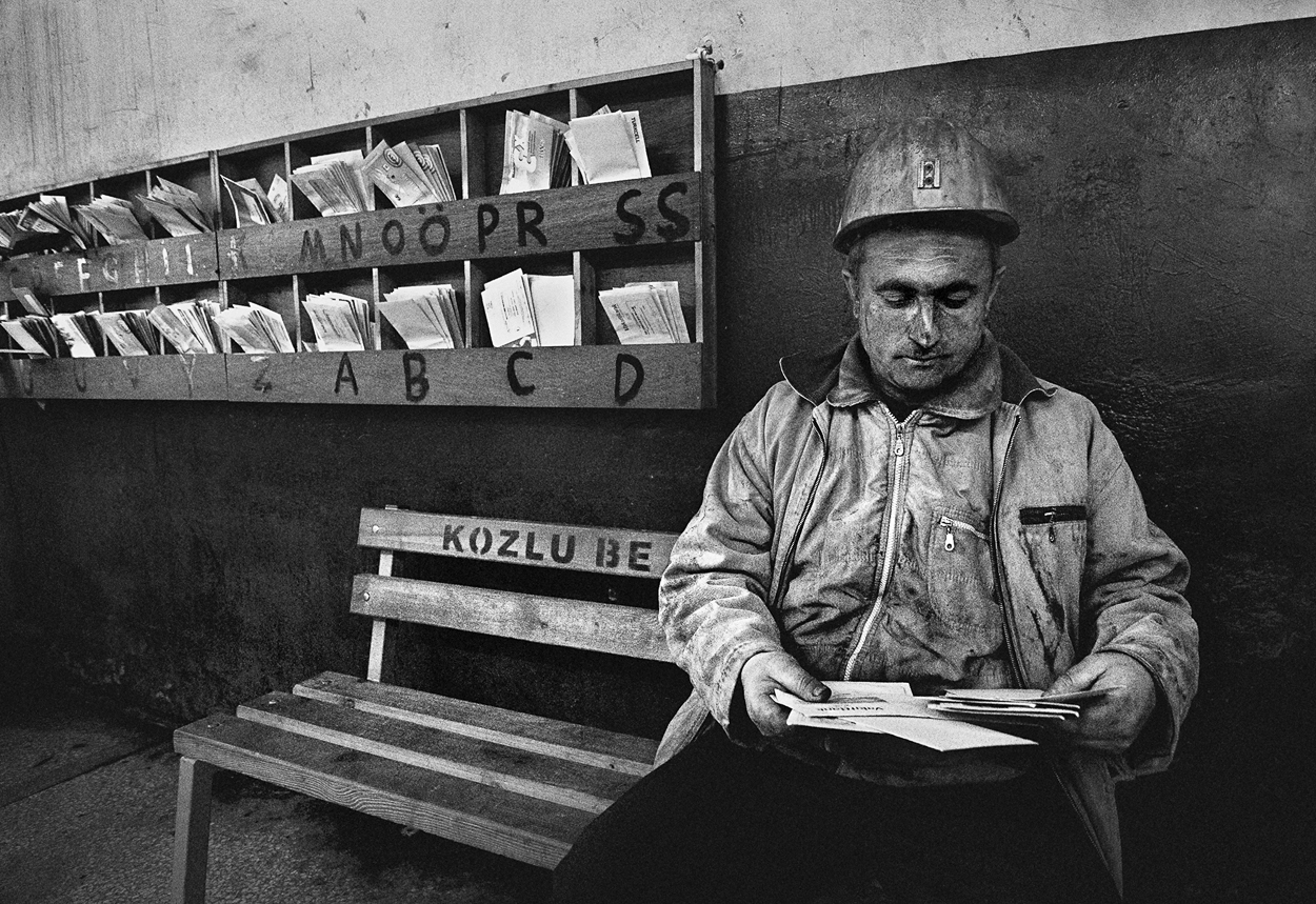 A man sitting on a bench reading a book.