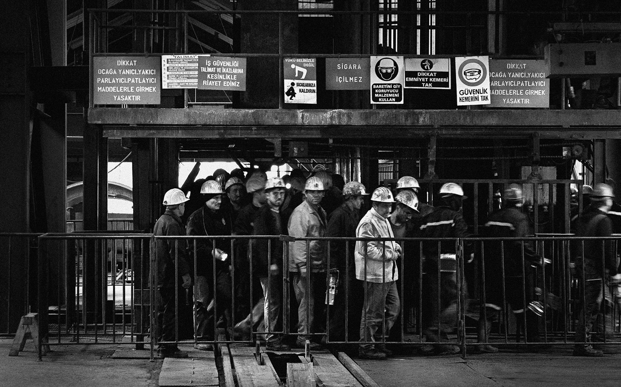 A group of men standing next to each other near a fence.