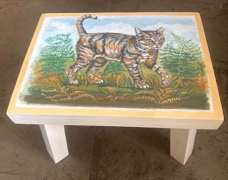 a small table with a painting of a cat on it