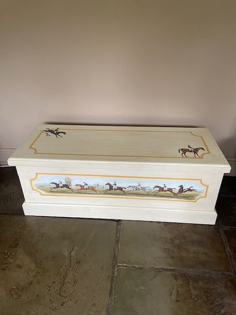 a wooden chest with a painting on it sitting on the floor
