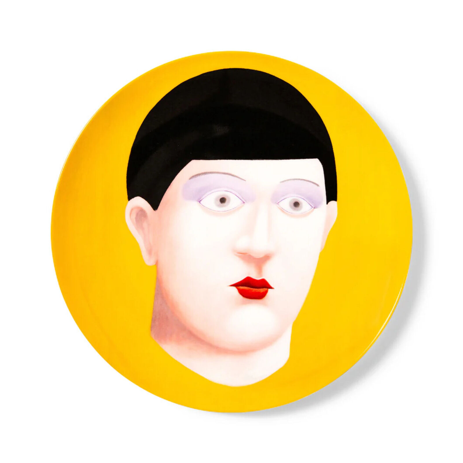 A yellow plate with a painting of a woman's face on it.