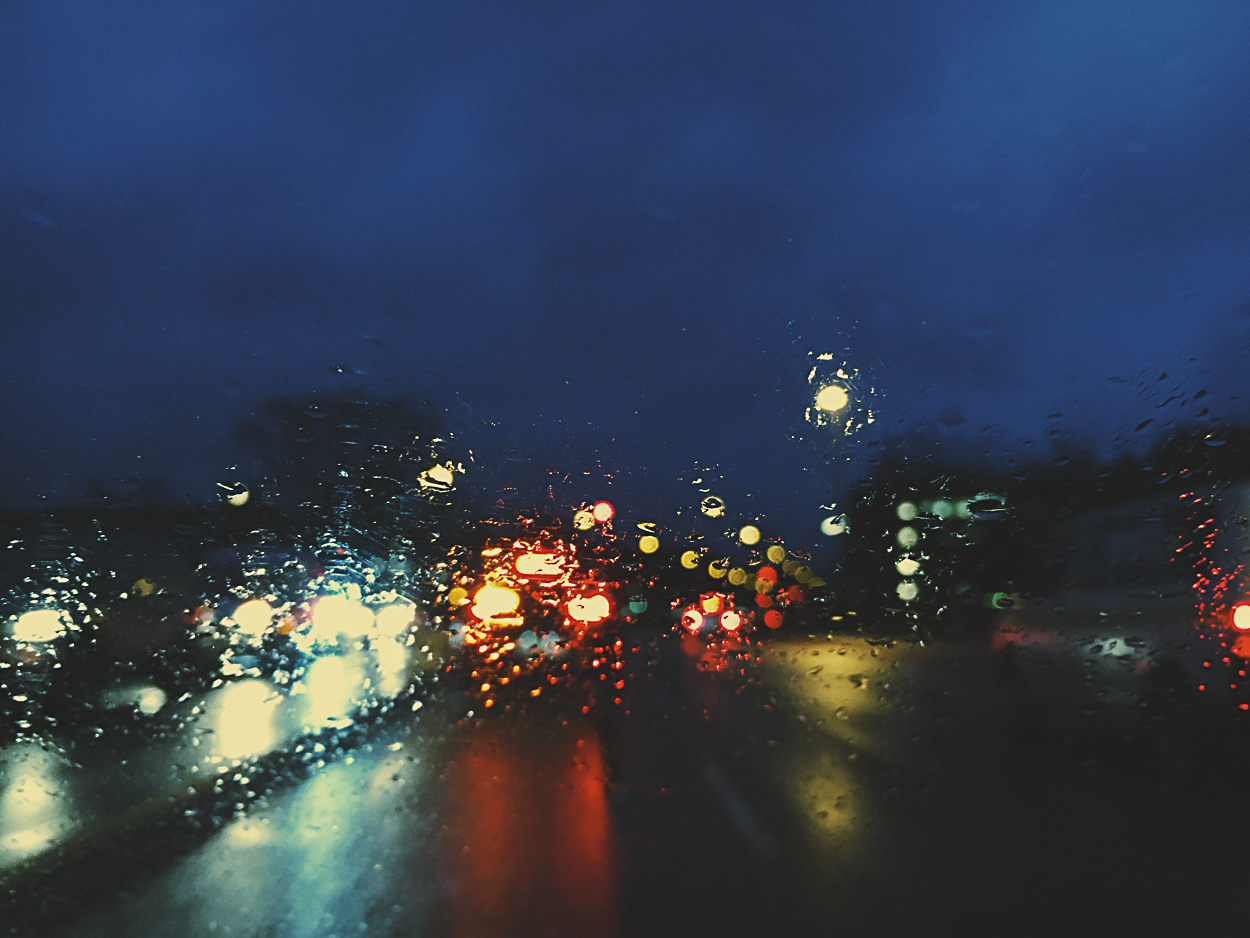 A view of a city street at night from a car window.