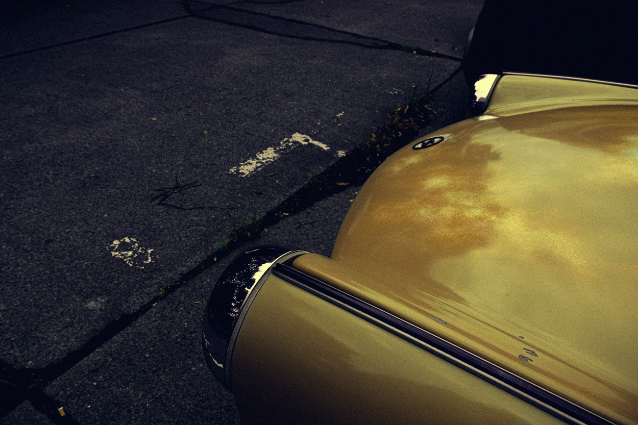 A yellow car parked on the side of the road.