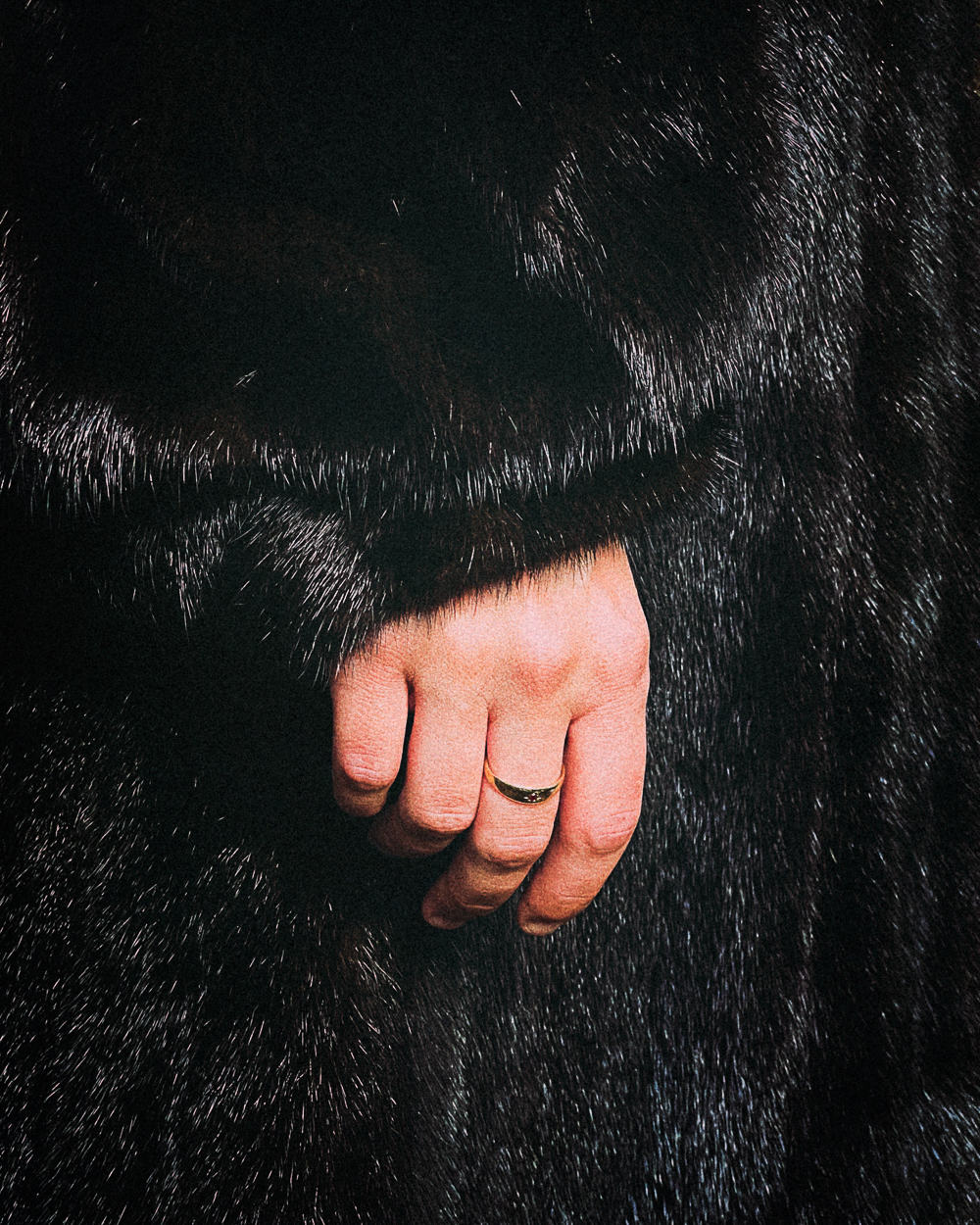 A close up of a person's hand with a ring on it.