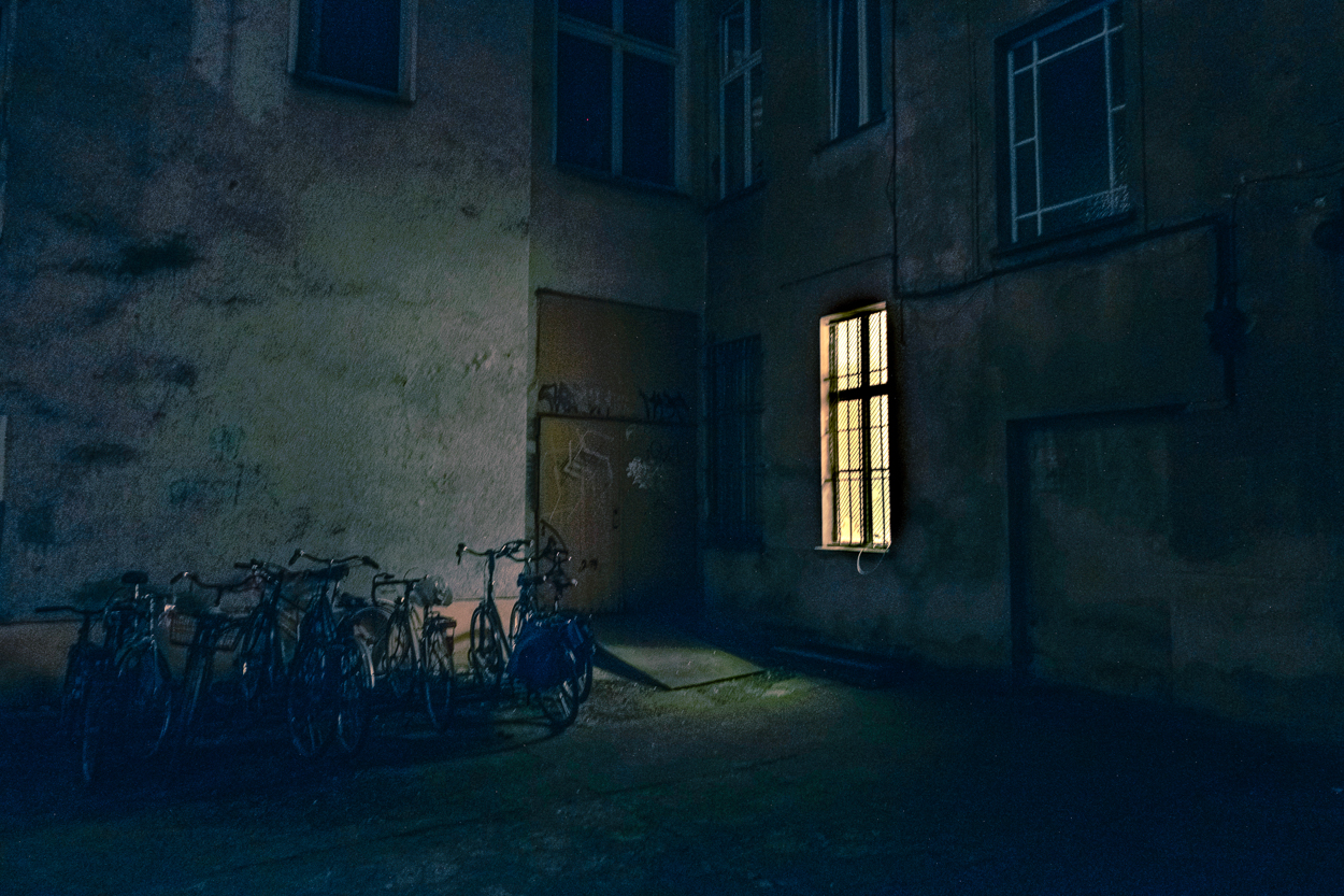 A row of bicycles parked in front of a building at night.