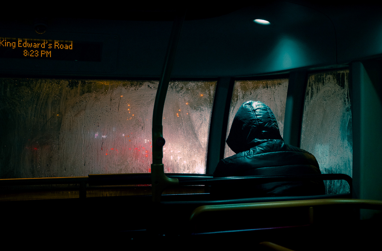 A person sitting on a bus looking out the window.