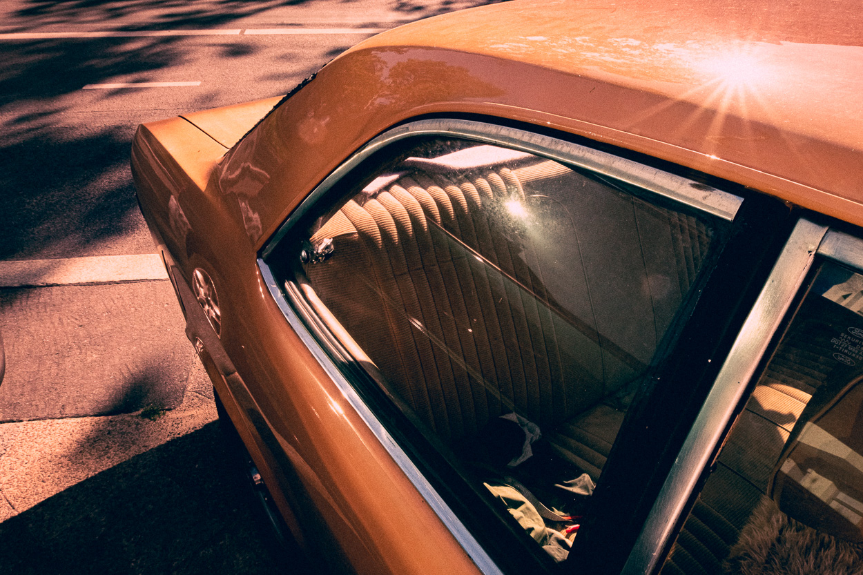 An orange car parked on the side of the road.