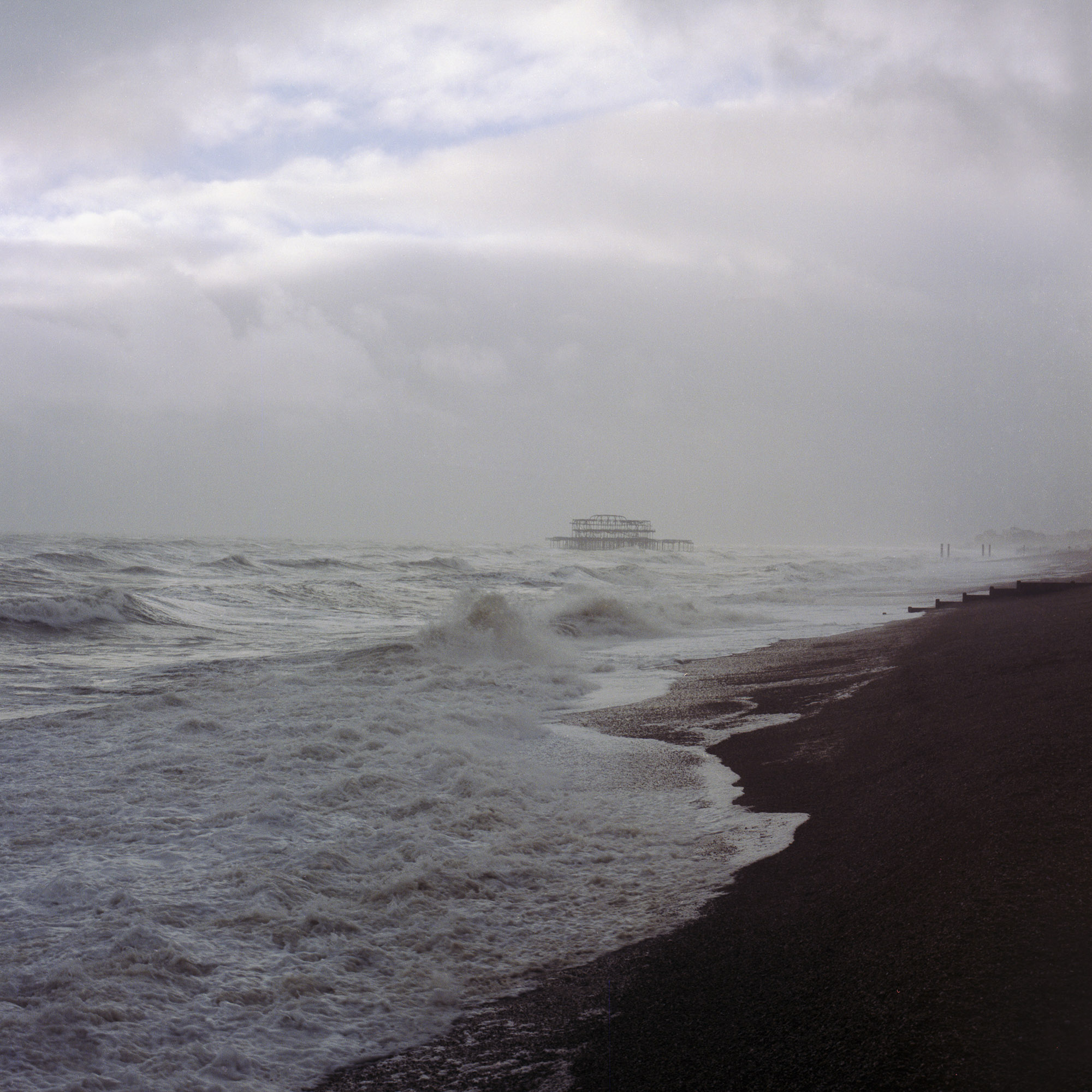 A view of a beach with waves crashing on the shore.