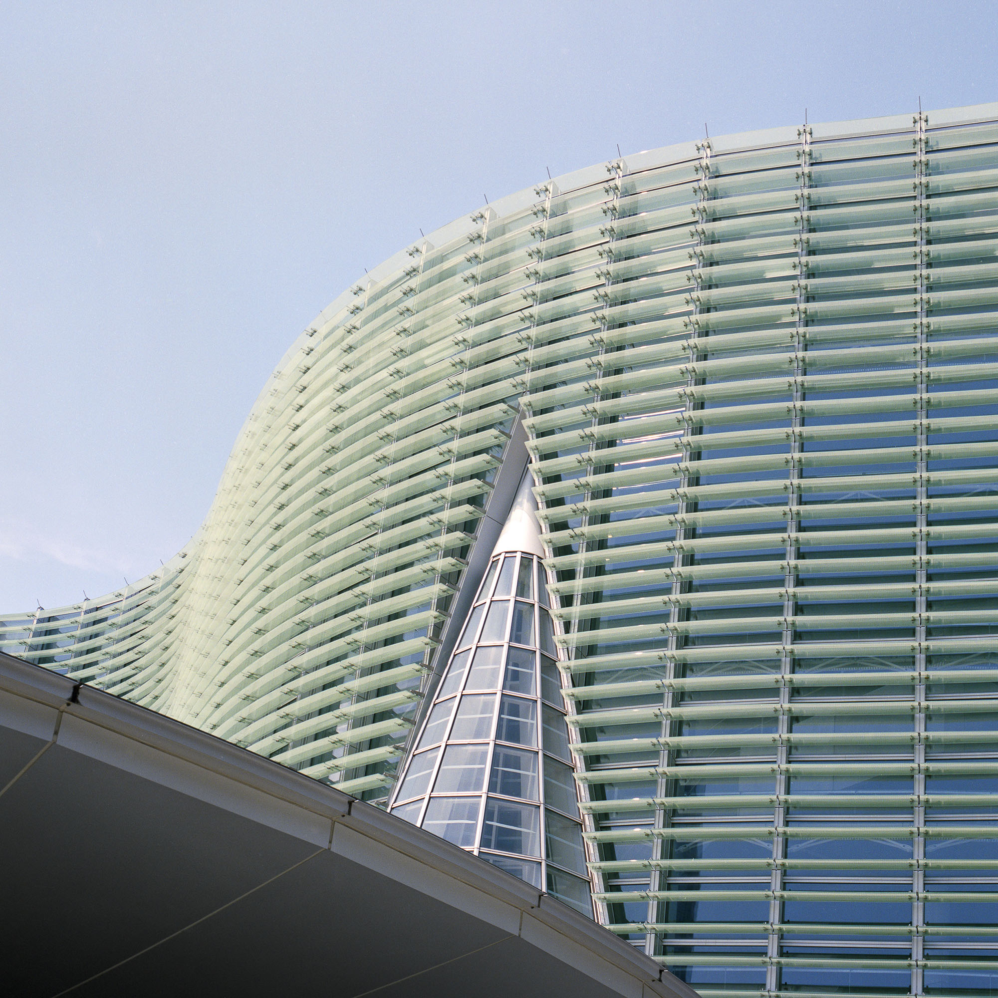 A tall building with many windows and a triangular shape.