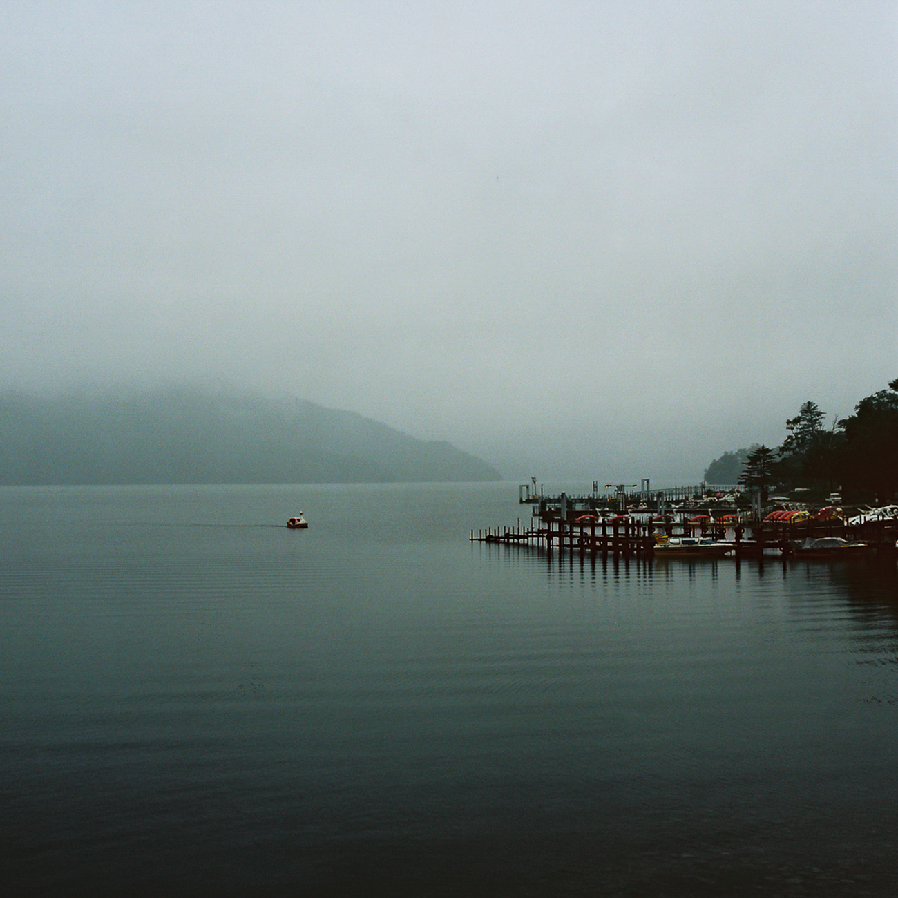 A foggy view of a body of water with boats in it.