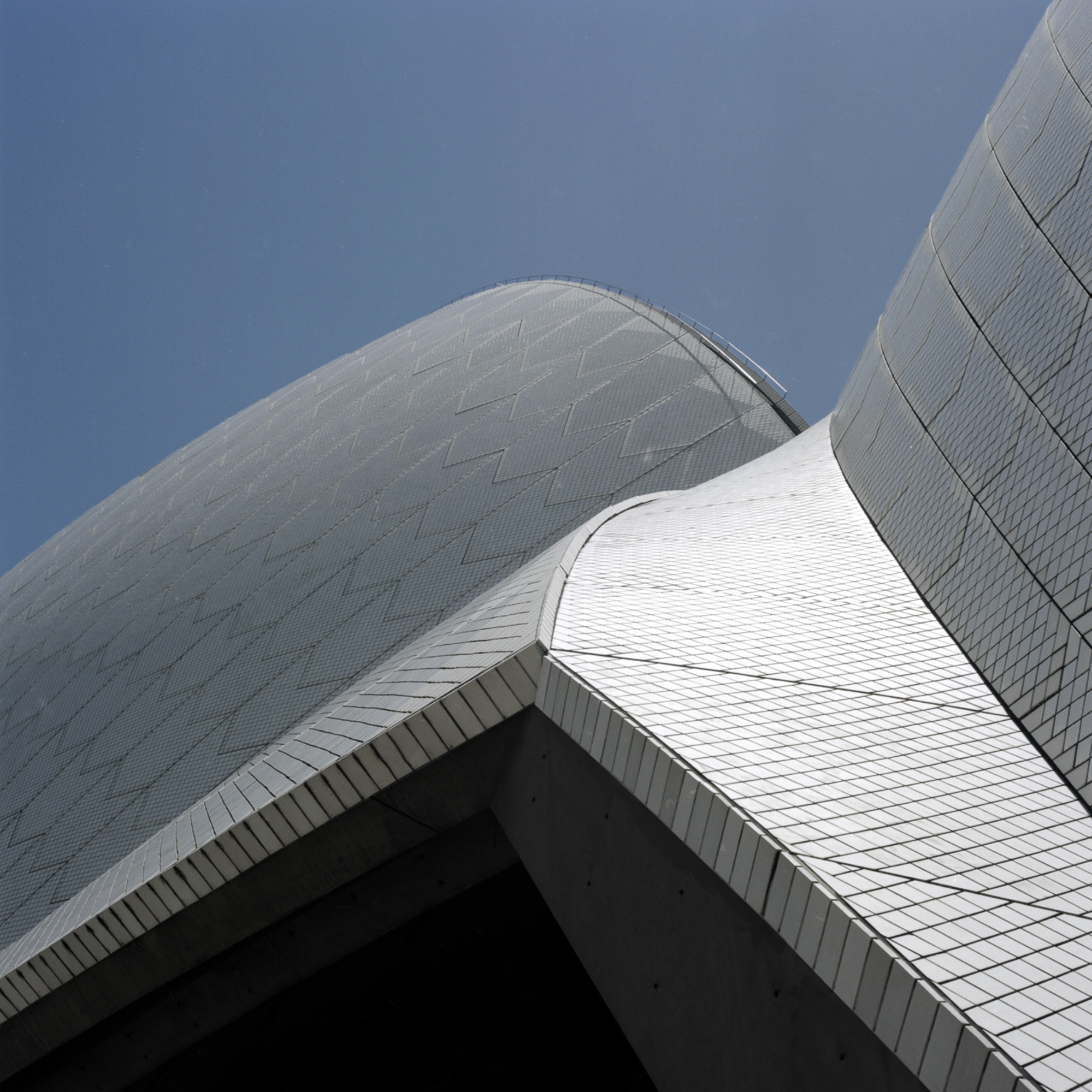 A close up of the roof of a building with a blue sky in the background.