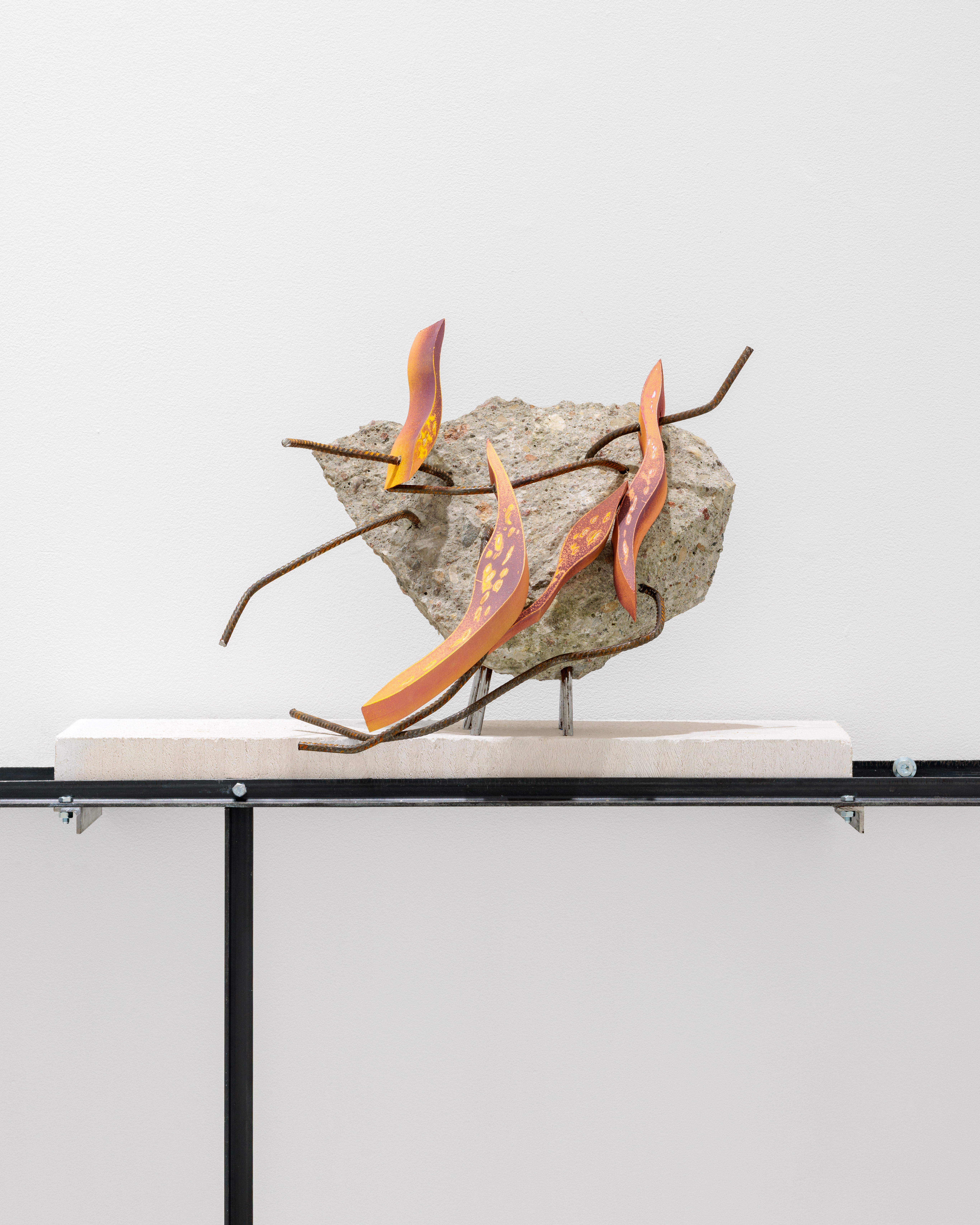 A sculpture on a metal stand on a white surface.
