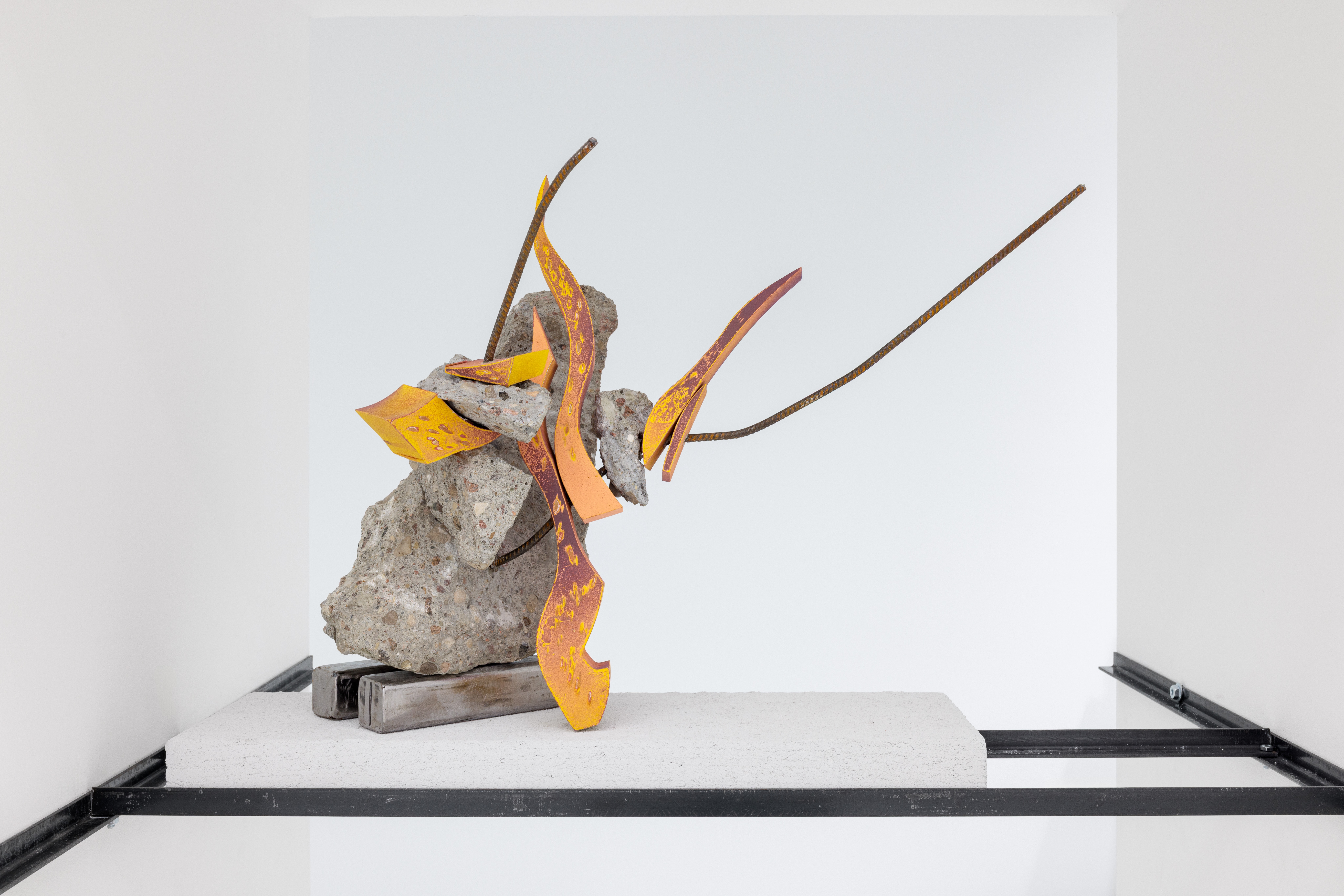 A sculpture on a shelf in a white room.