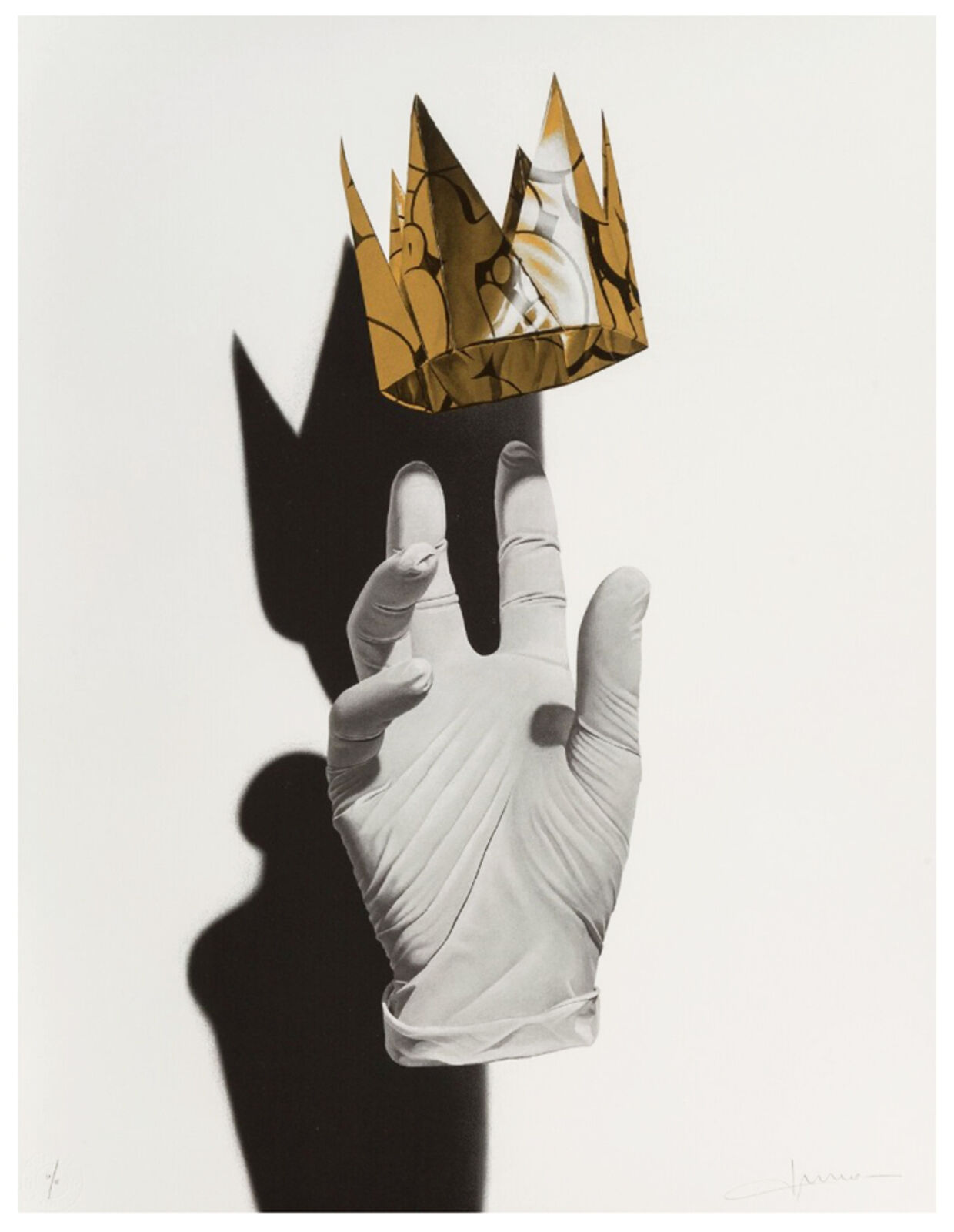 A black and white photo of a hand holding a paper crown.