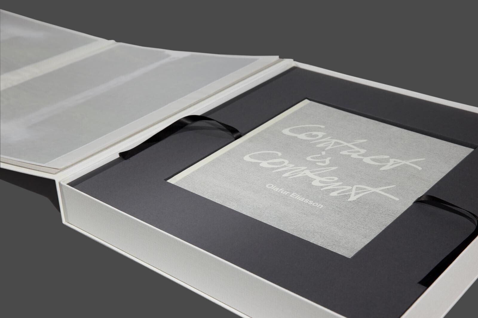 A white box with a black ribbon around it.