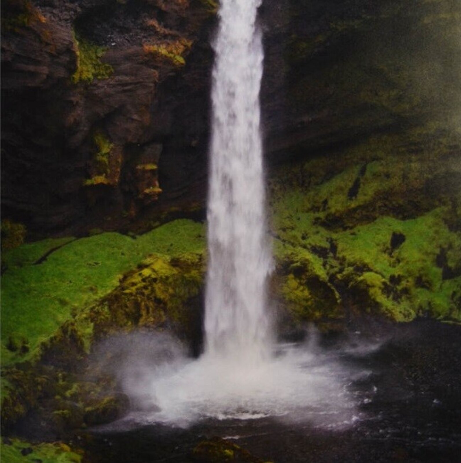 A split-panel framed artwork of a waterfall cascading over mossy rocks.