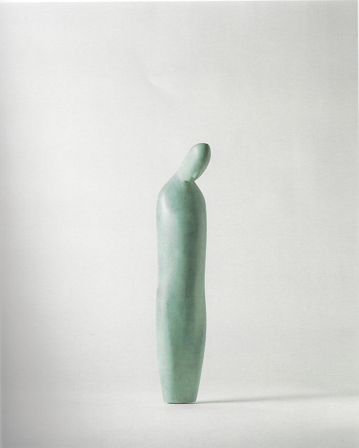 A green vase sitting on top of a white surface.