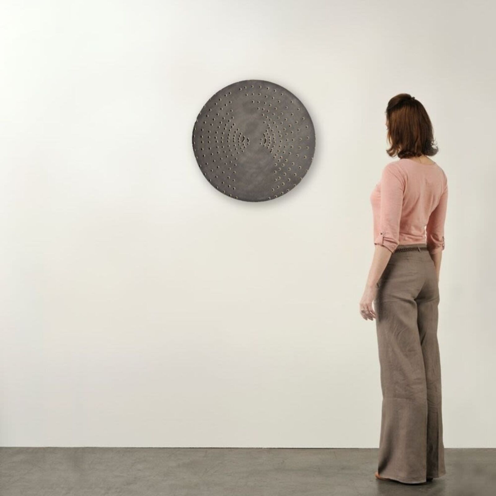 A circular metal plate with holes in the middle of it.