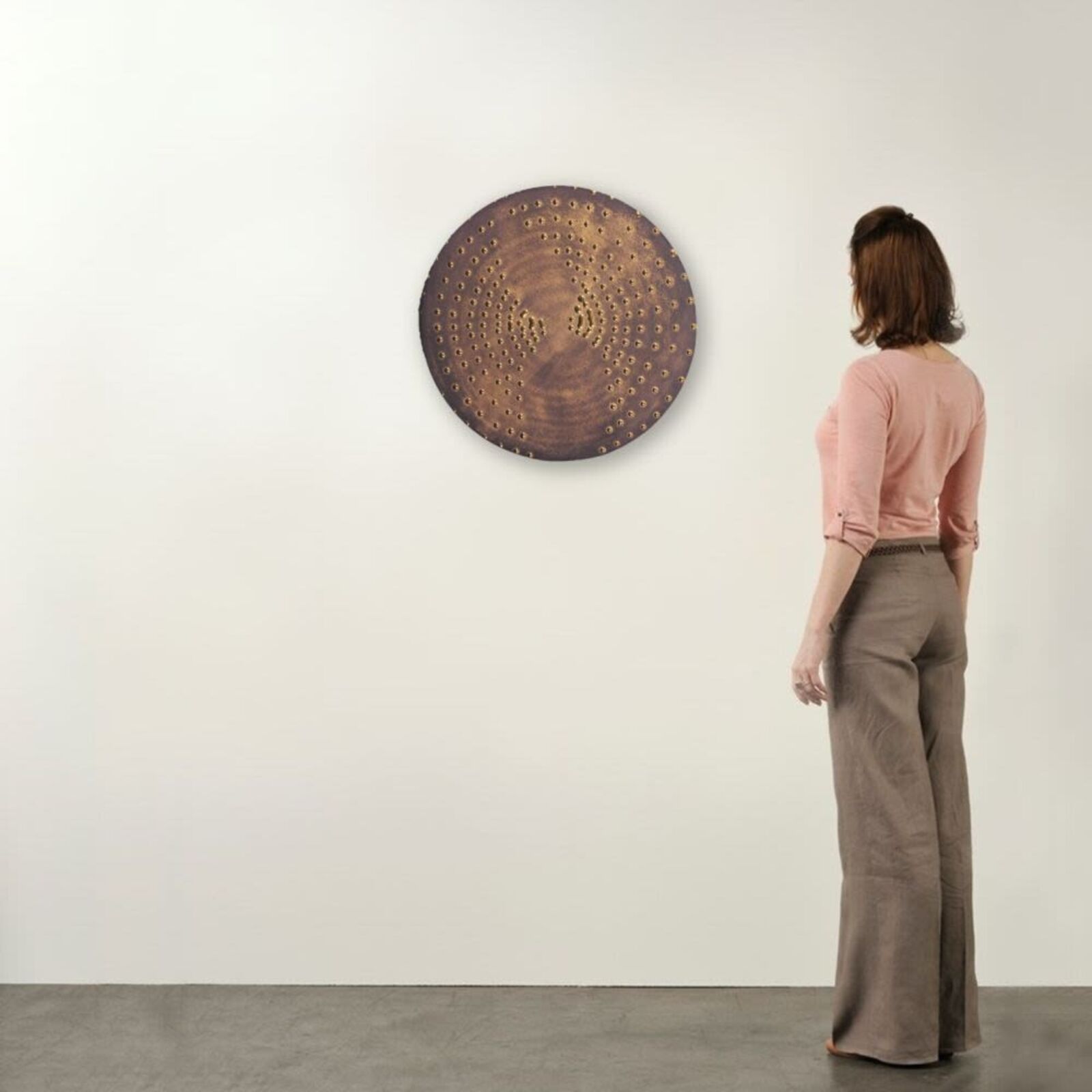 A circular metal plate with holes in it. 