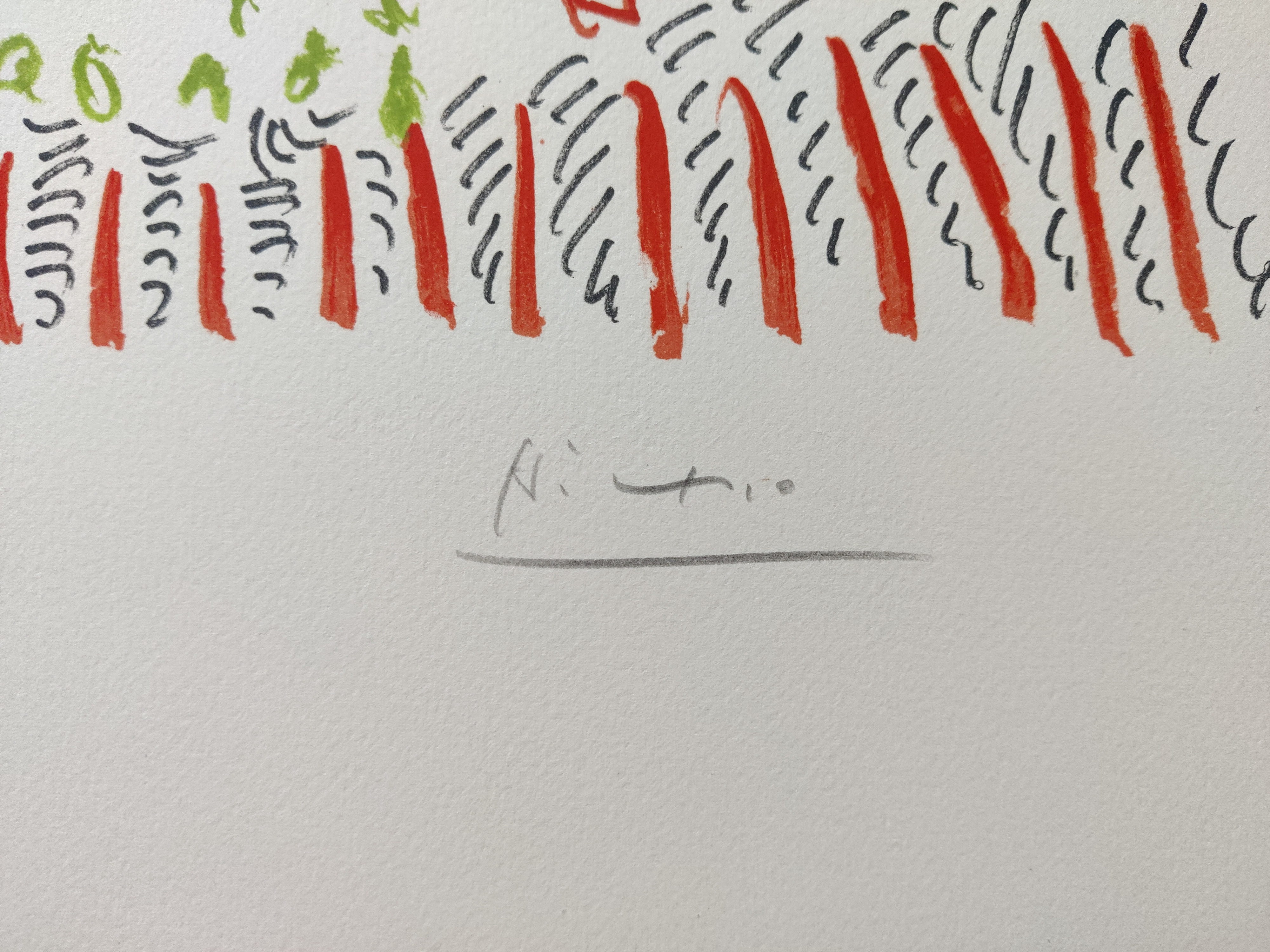 A framed picture of a clown face in a gold frame.