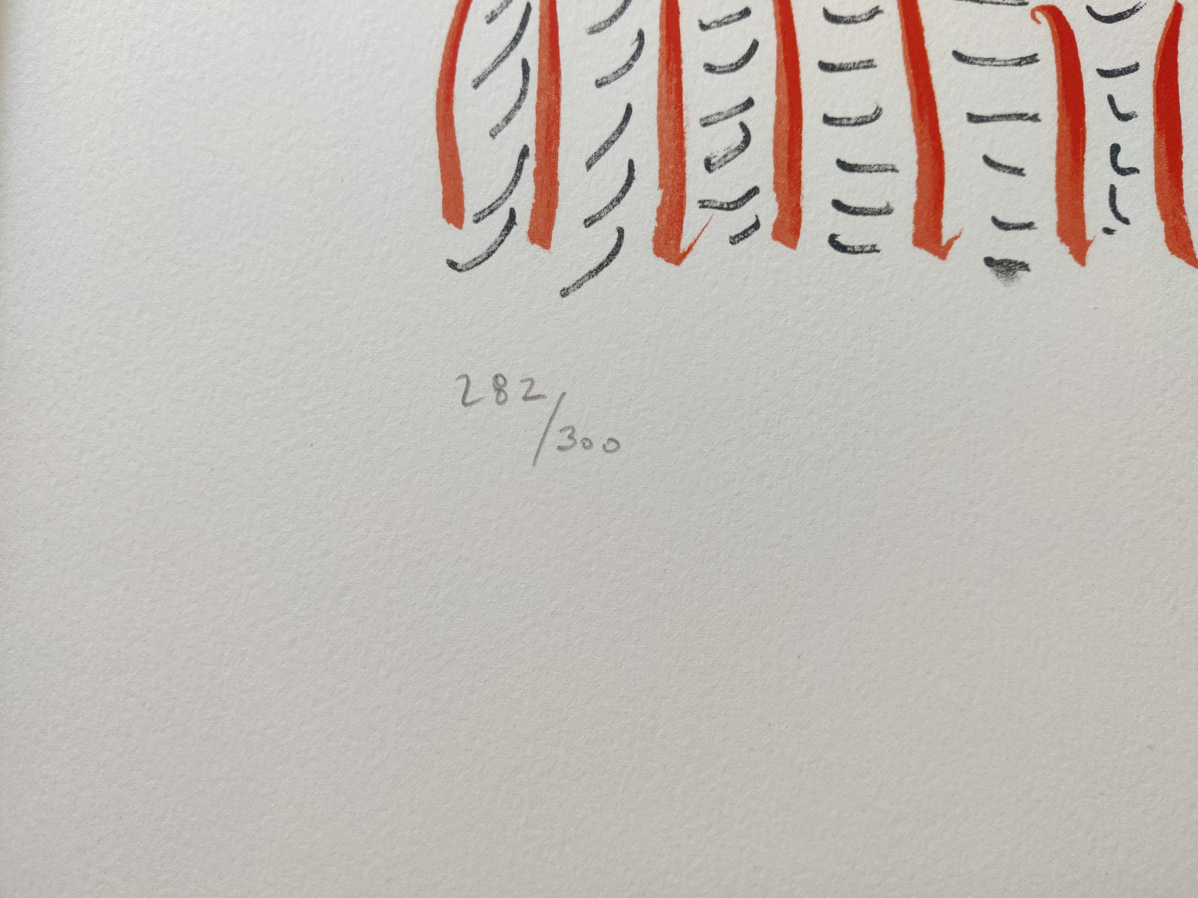 A framed picture of a clown face in a gold frame.