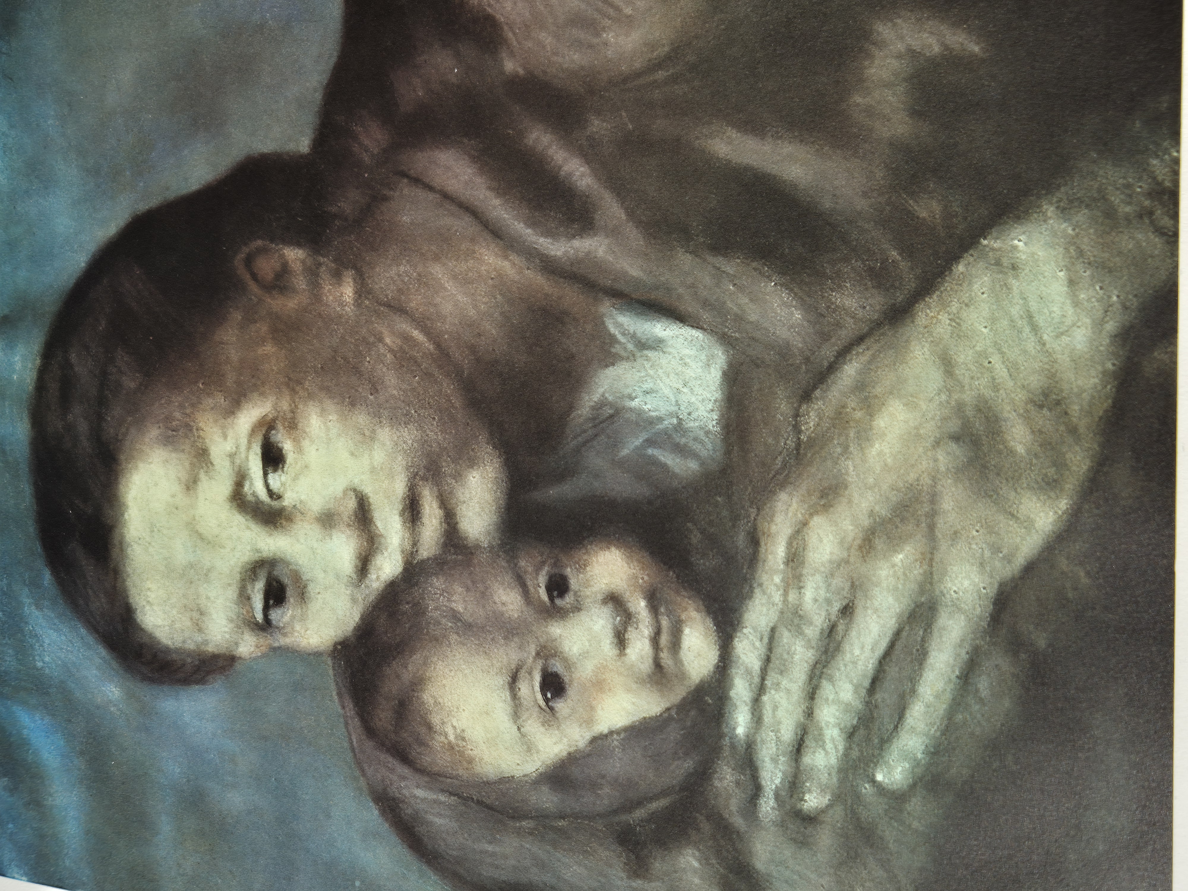A somber portrait of a woman holding a child against a muted blue background.