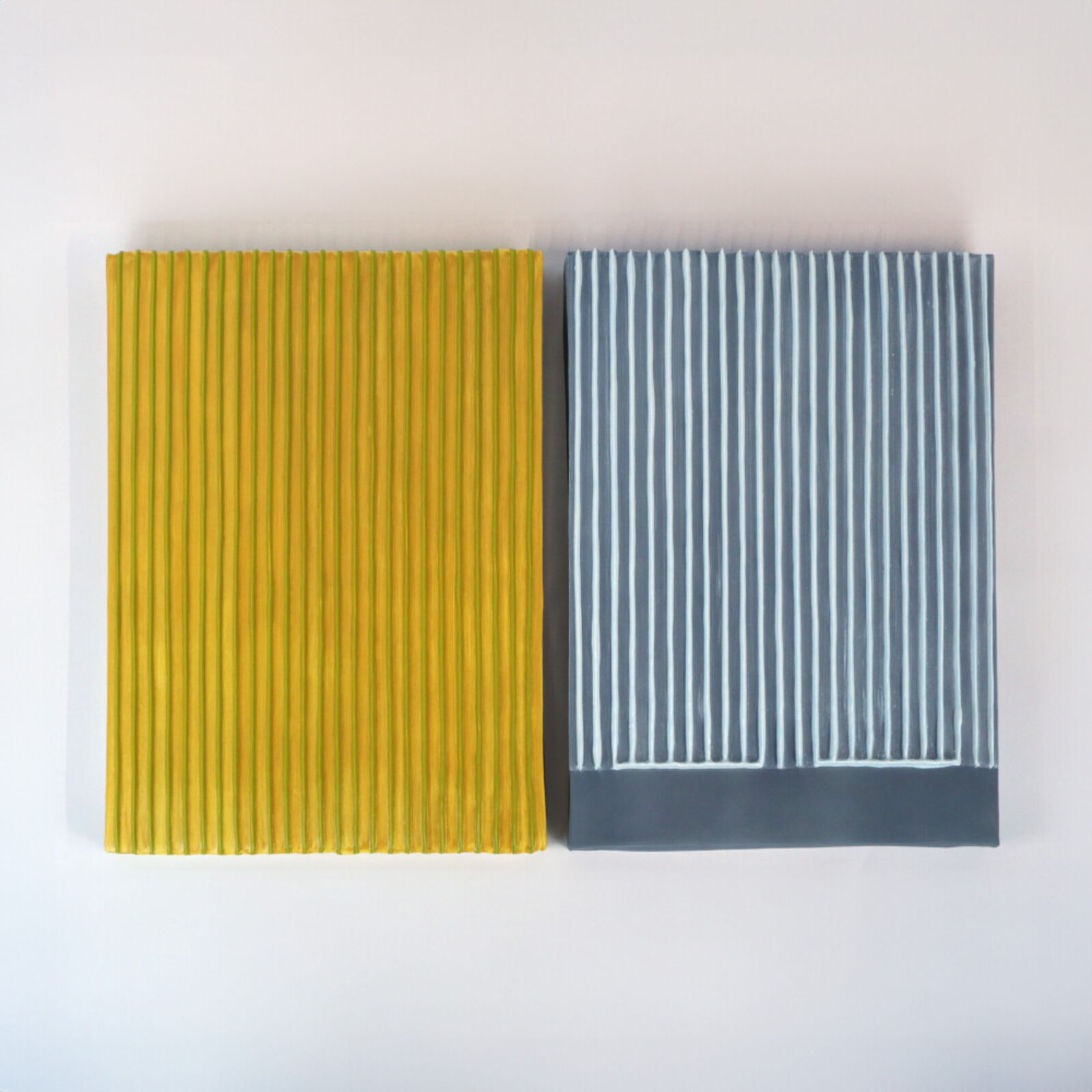 Two pieces of yellow and blue paper on a white surface.