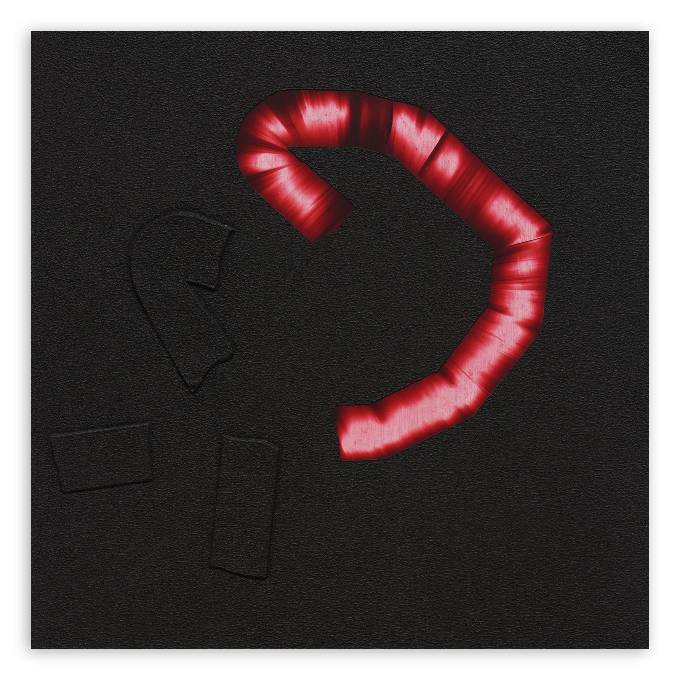 A red candy cane on a black background. 