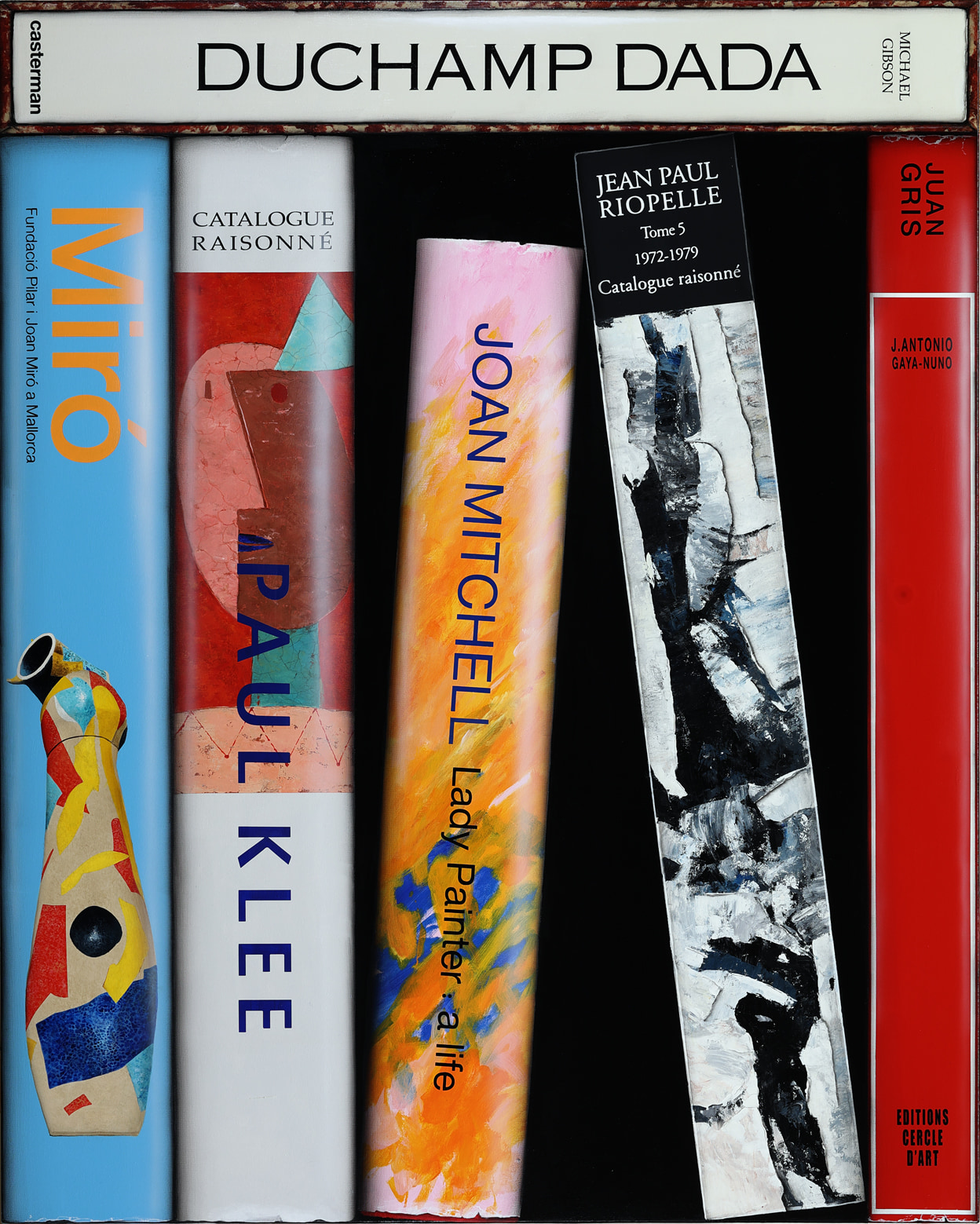 A set of four books sitting on top of each other.