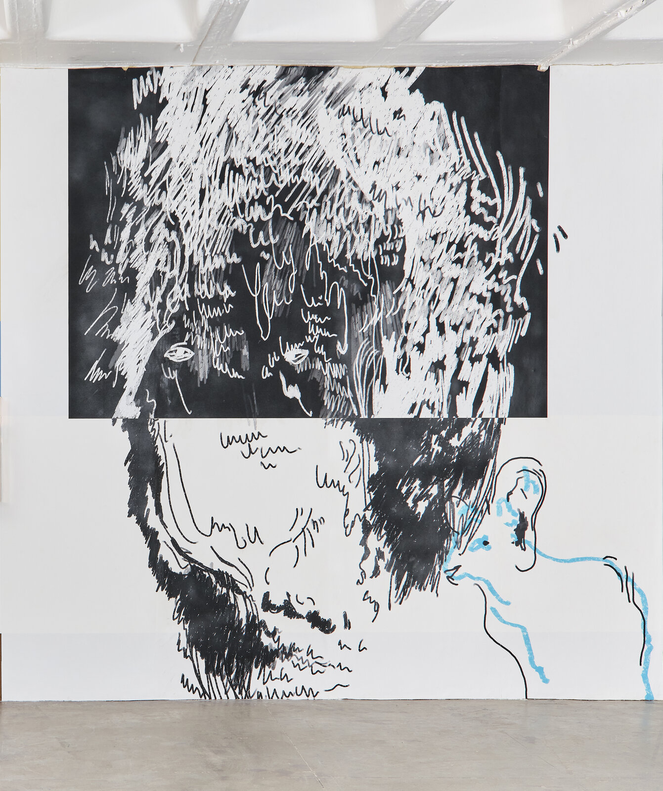 A black and white drawing of a man's face on a wall.