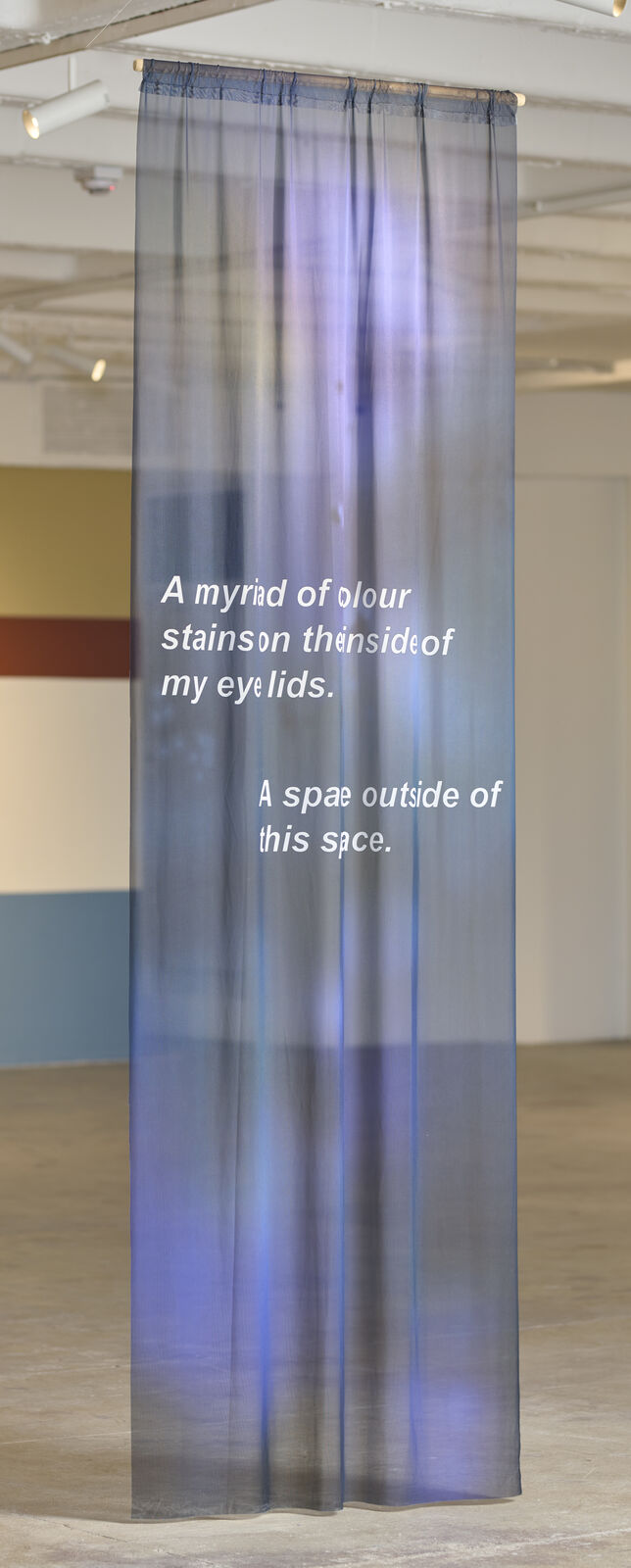 A room with a large painting on the wall and a blue light on the ceiling.