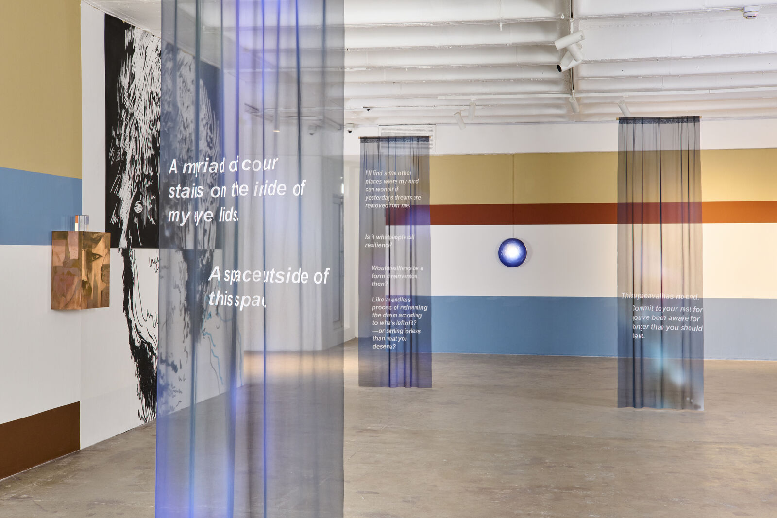 A room with a large painting on the wall and a blue light on the ceiling.