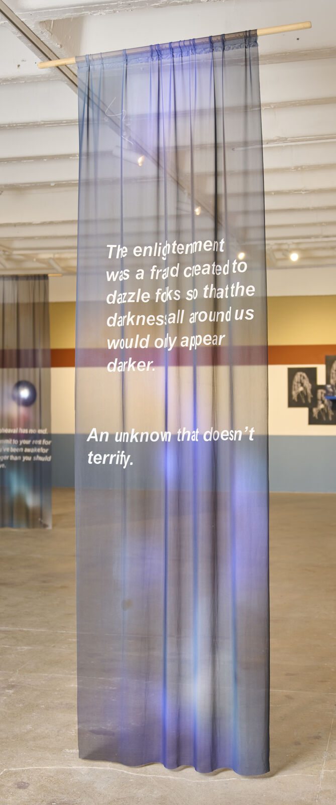 A room with a large painting on the wall and a blue light on the ceiling.