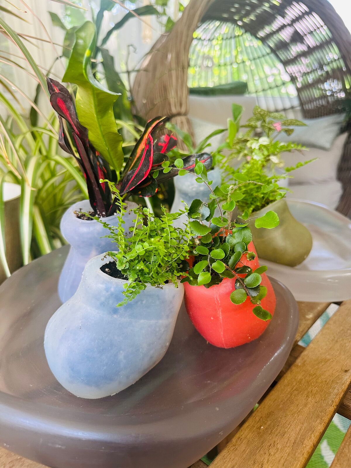 Artwork by Paula Hayes, Six mini silicone planters and two trays, Made of Planters: Cast silicone, Trays: Cast resin 